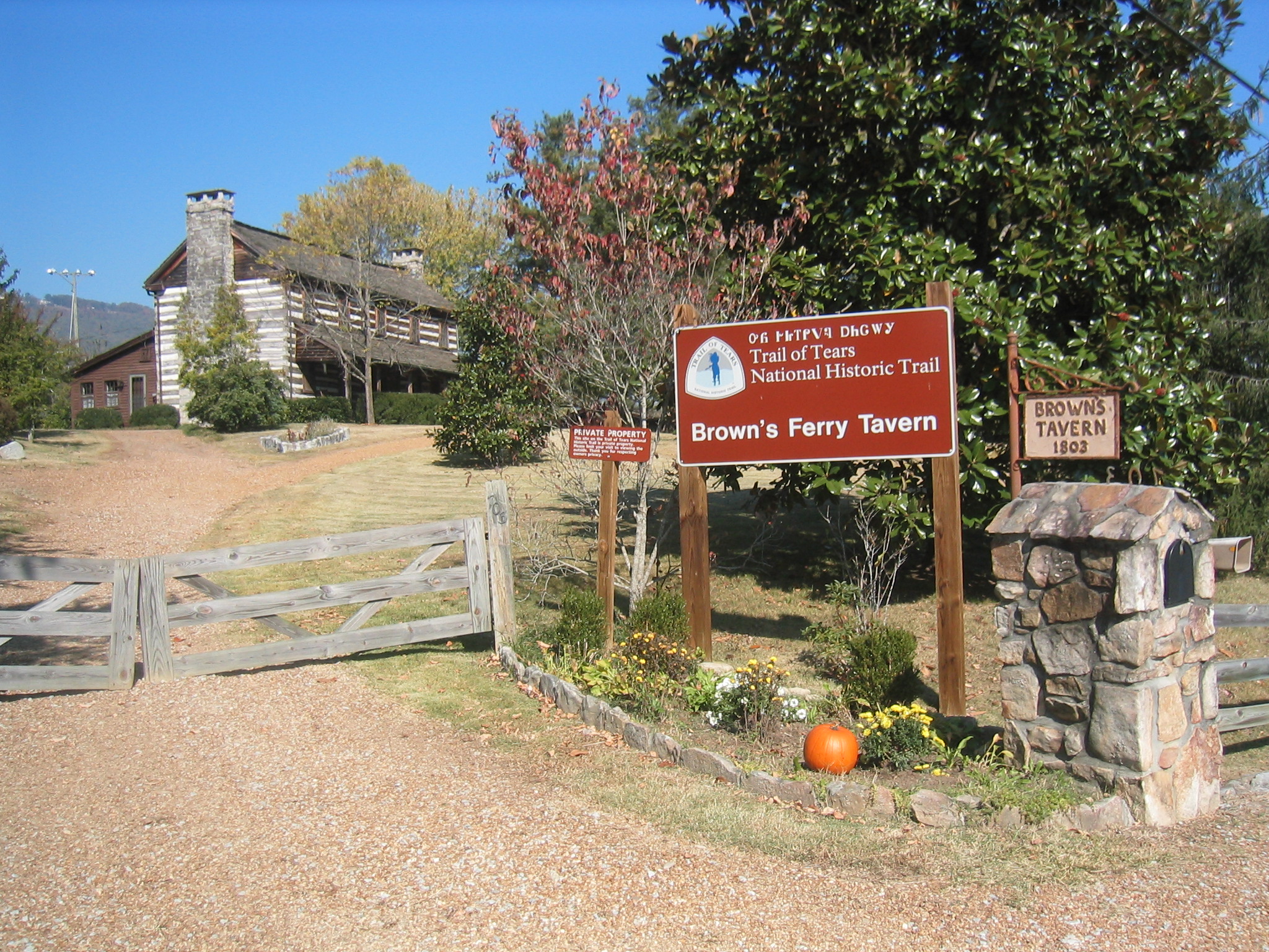 structure in the background with large chimney on the end; signs saying Brown's Ferry Tavern