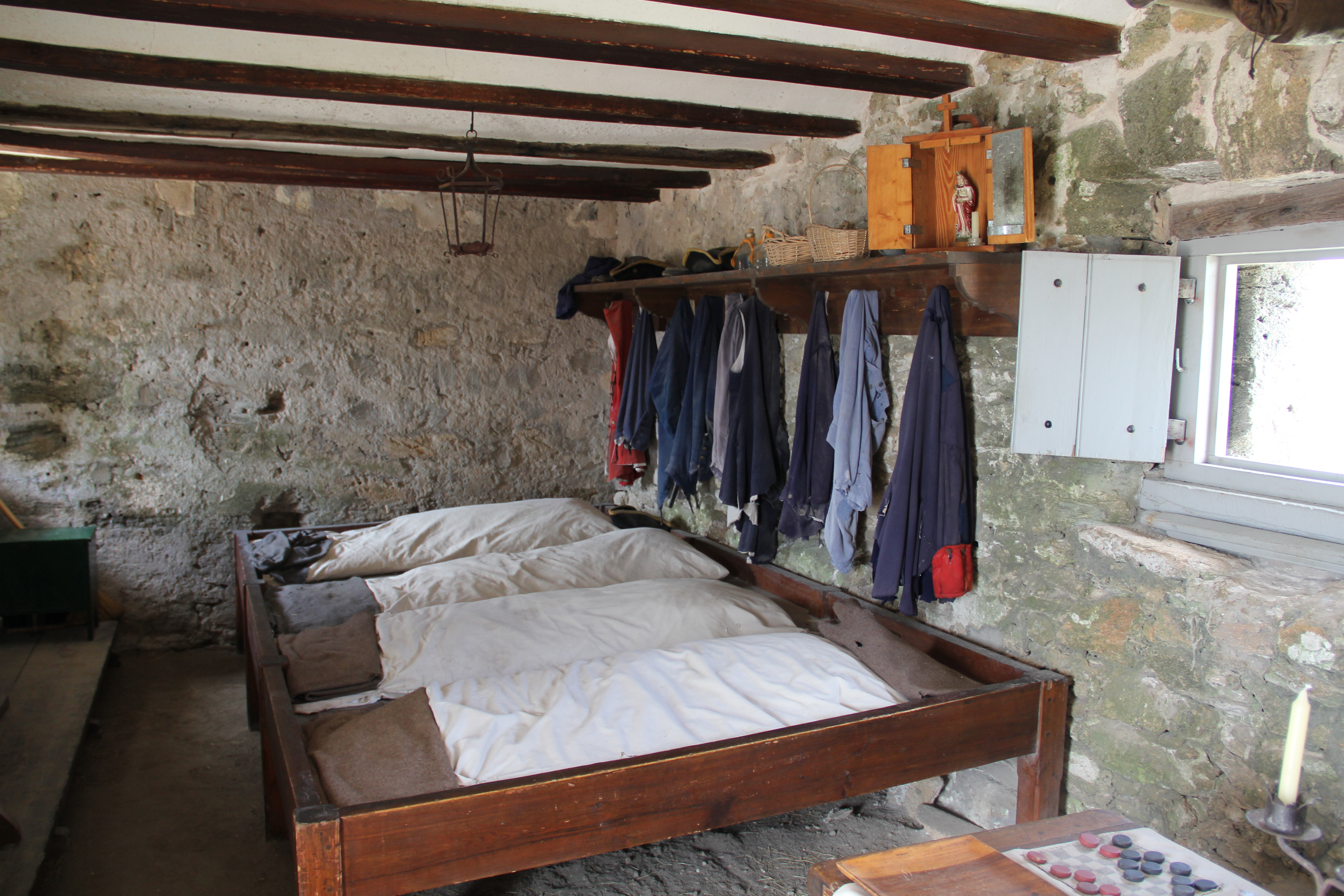 Wooden bunks and uniform items in the soldier's quarters.