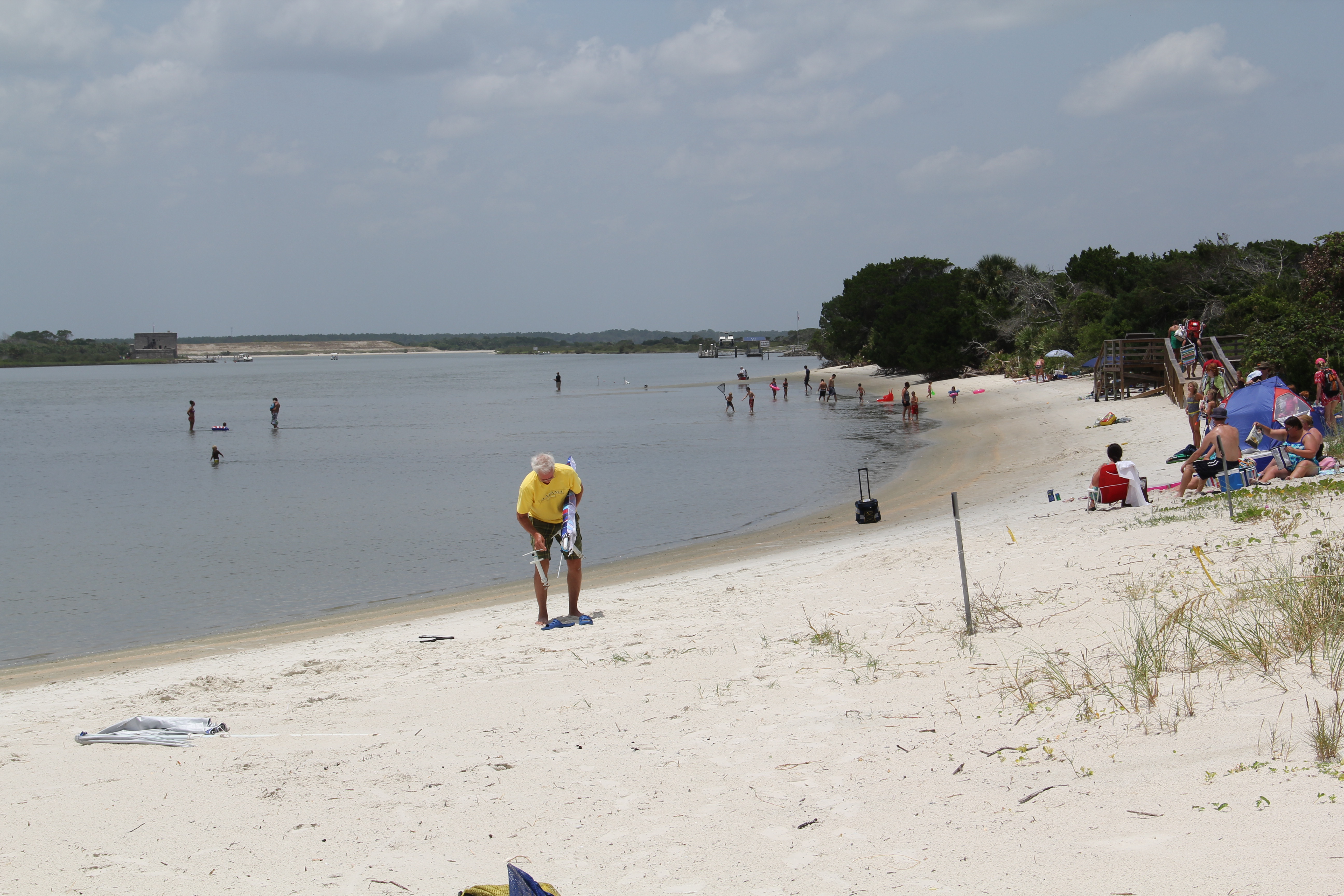 People wading in the river and relaxing on the beach.