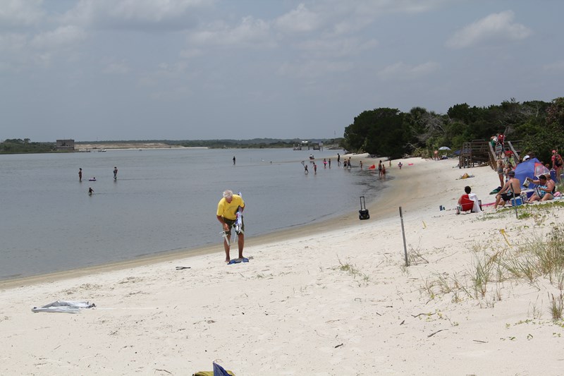 Recreational Opportunities People wading in the river and relaxing on the beach.