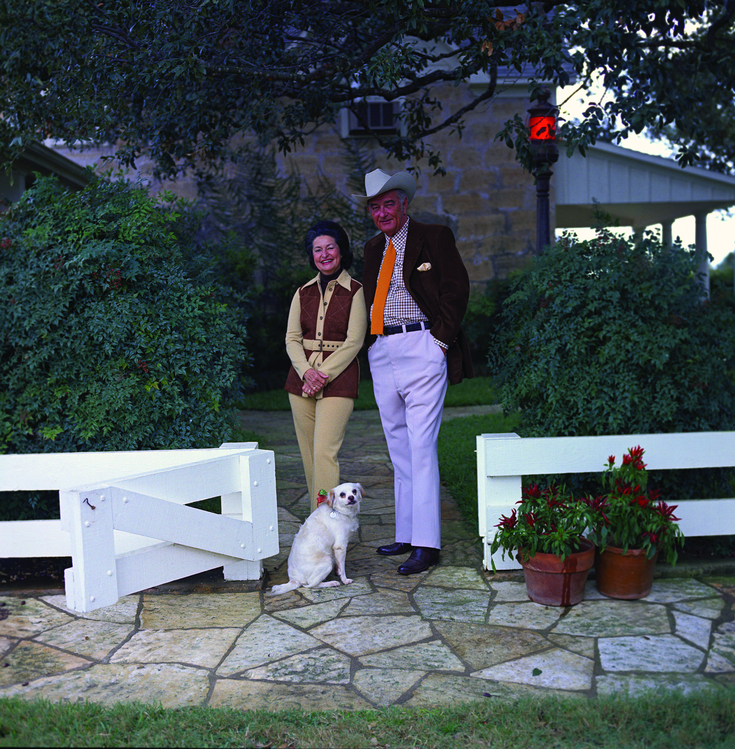 President and Mrs. Johnson stand outside the Texas White House with dog Yuki.