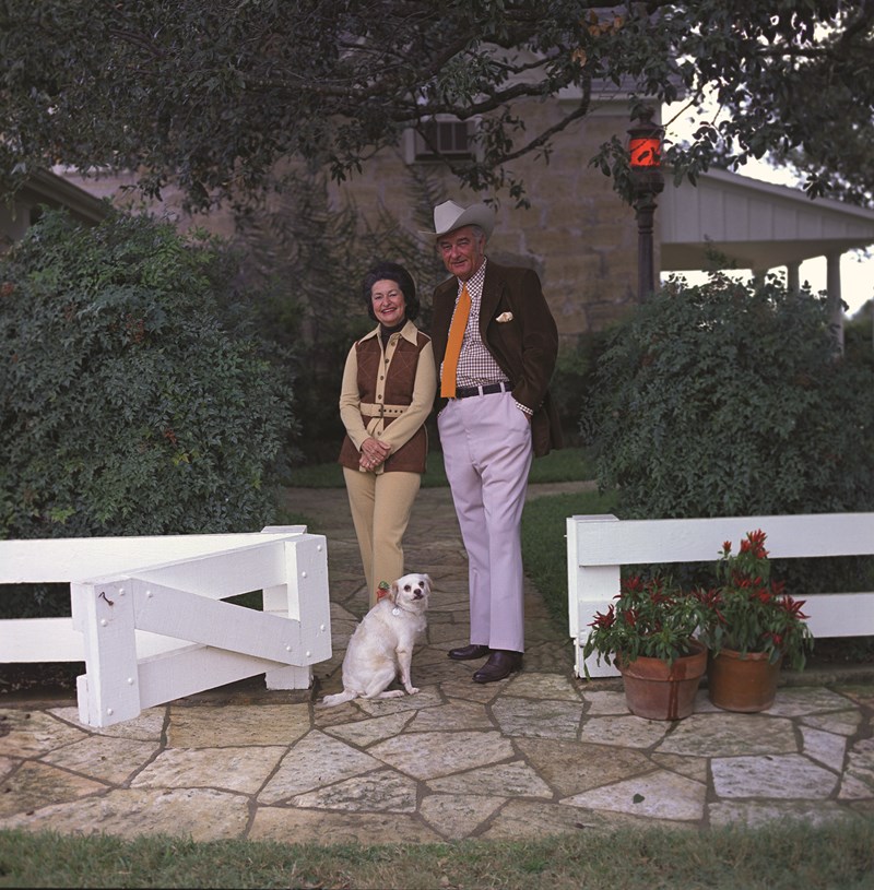 Portrait of the Johnsons President and Mrs. Johnson stand outside the Texas White House with dog Yuki.