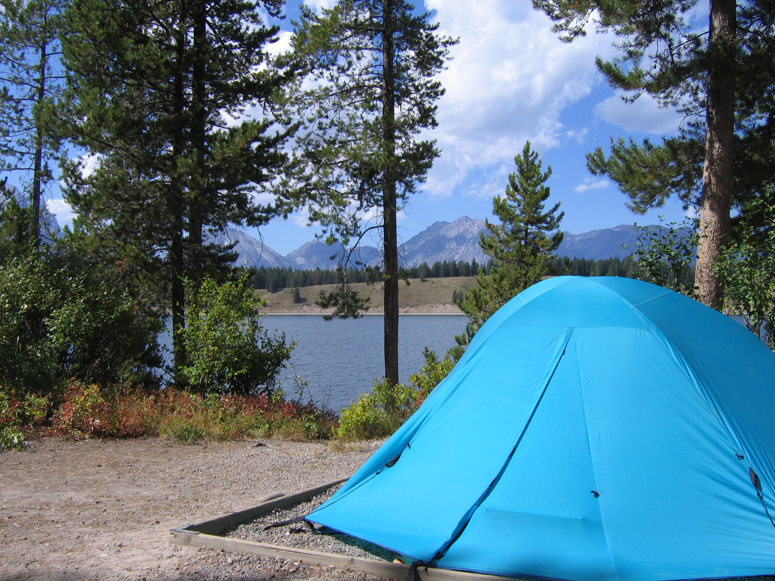 Blue tent with Jackson Lake and the Teton Range in the background