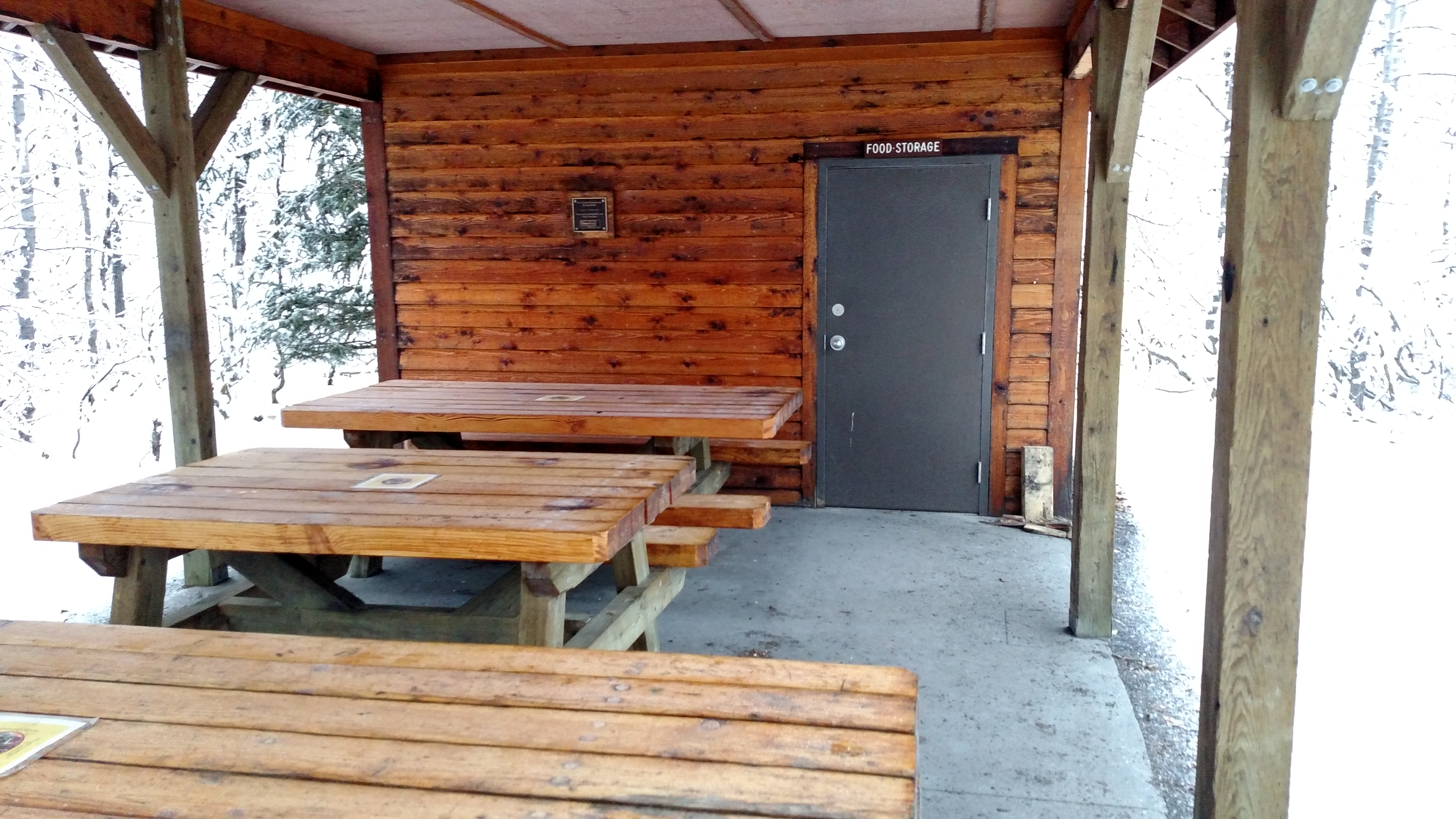 cook shelter with picnic tables and food storage closet.