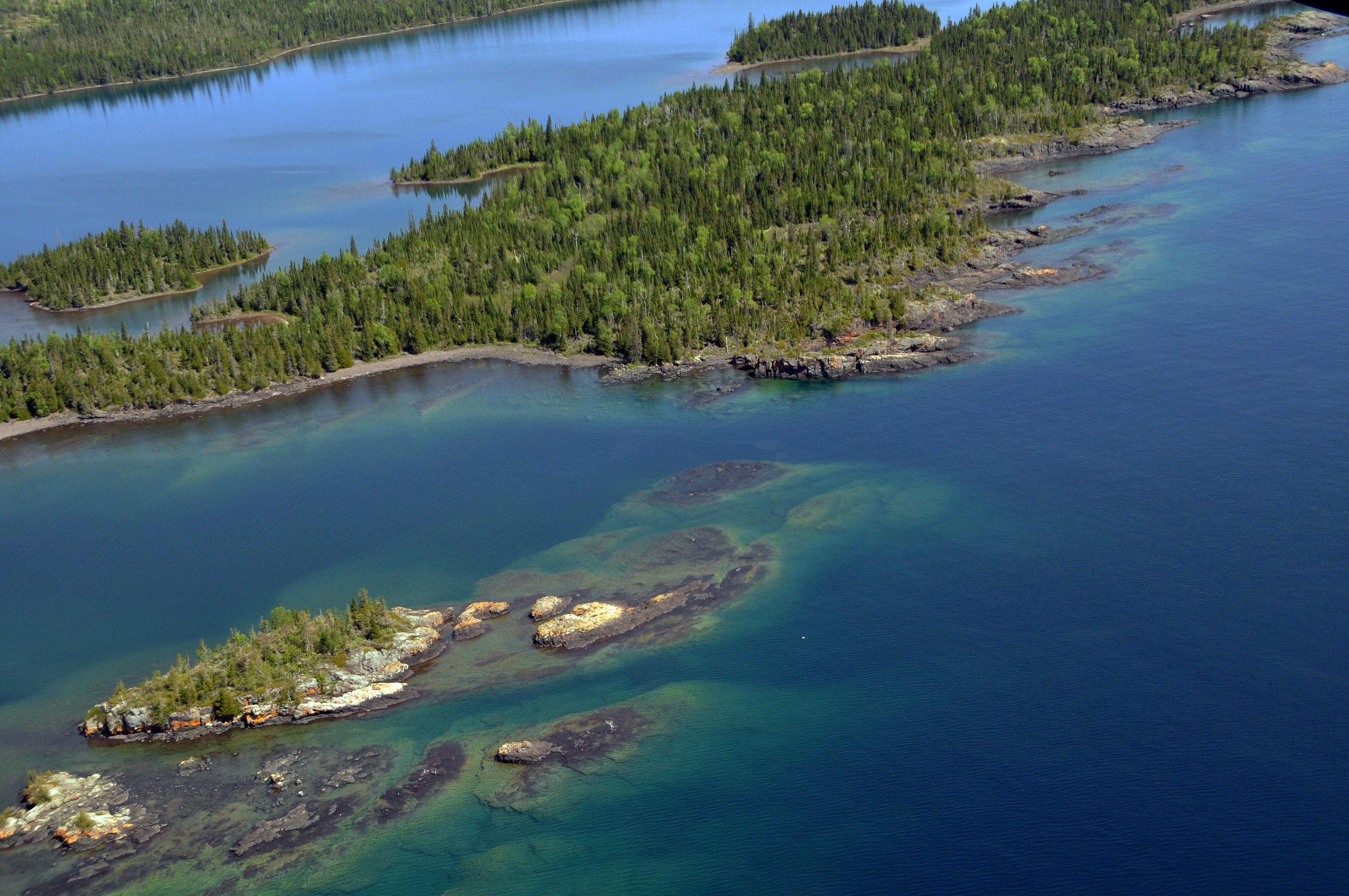 Aerial view of West Caribou Island surrounded by the blue waters of Lake Superior.