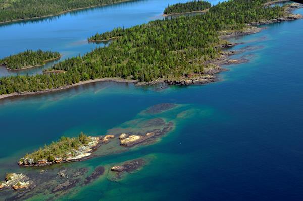 Aerial view of West Caribou Island surrounded by the blue waters of Lake Superior.
