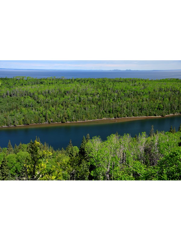 Aerial view of the blue waters of Duncan Bay Narrows and the surrounding green, boreal forest.