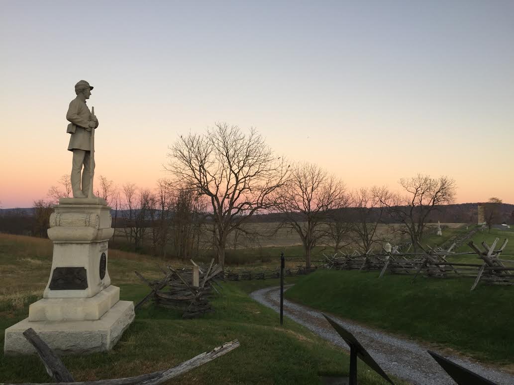 a monument of a soldier at sunset