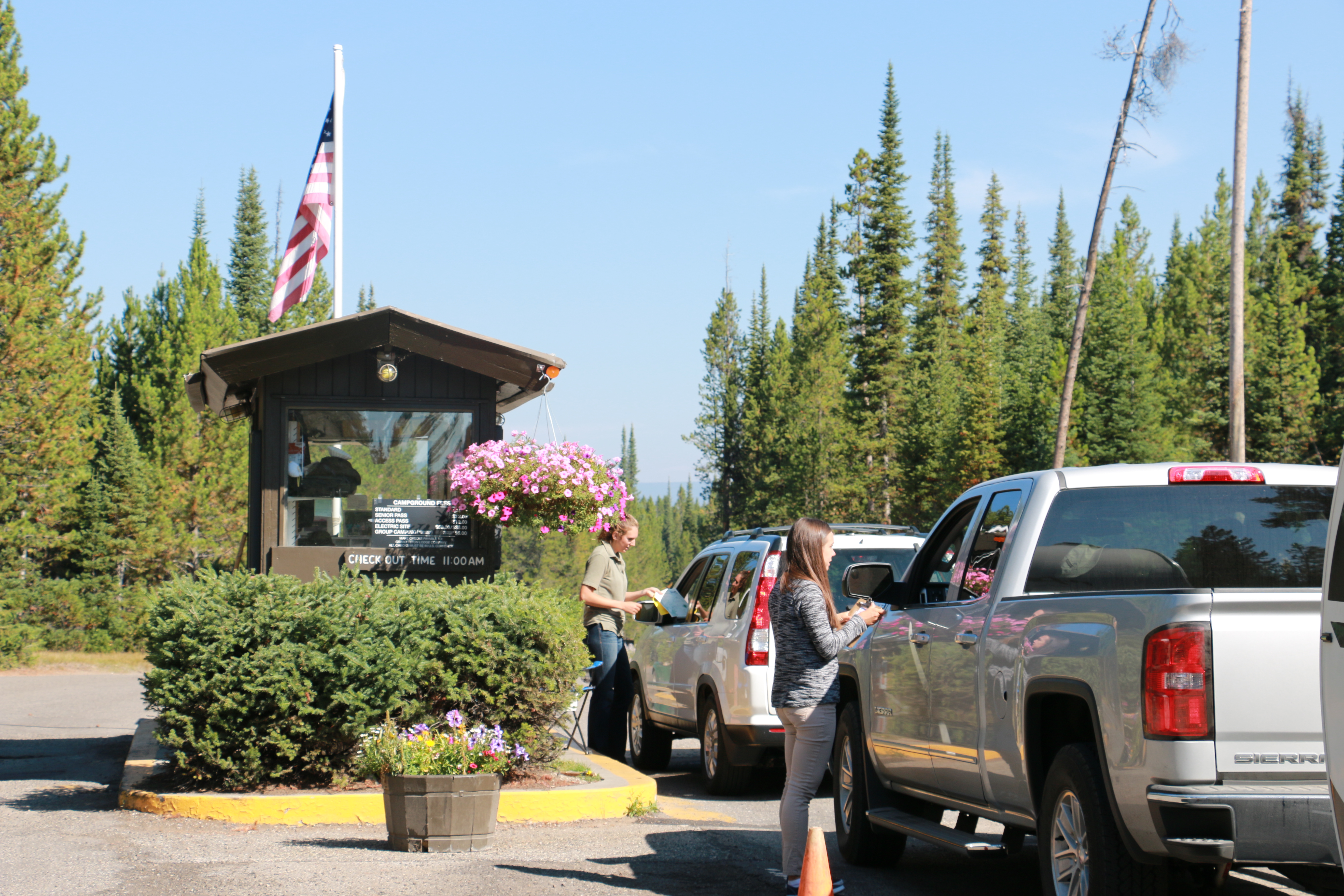 vehicles waiting to pay camping fees at entrance booth to campground