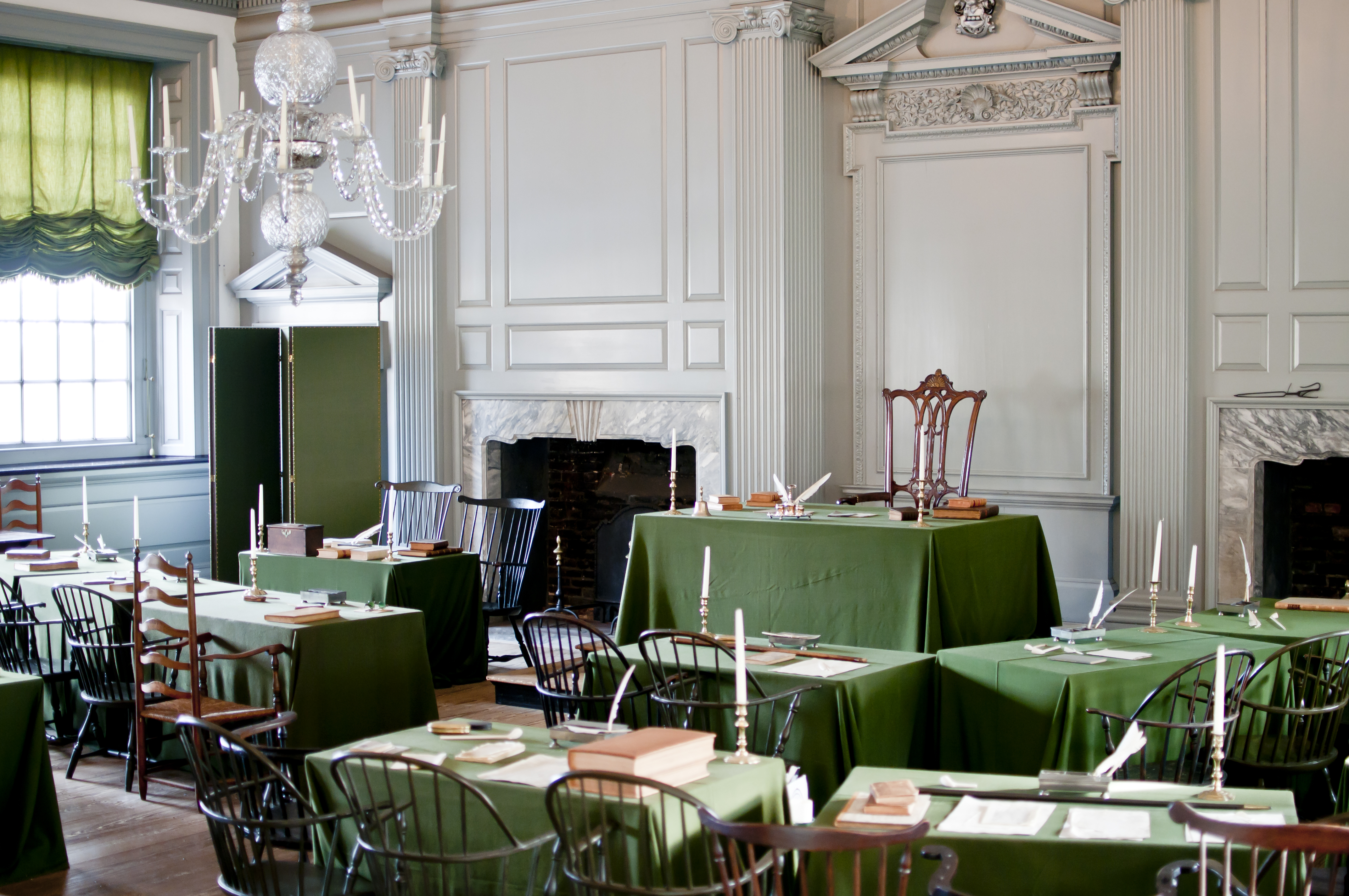 A color photo of the Assembly Room showing 18th century chairs and green, cloth covered tables