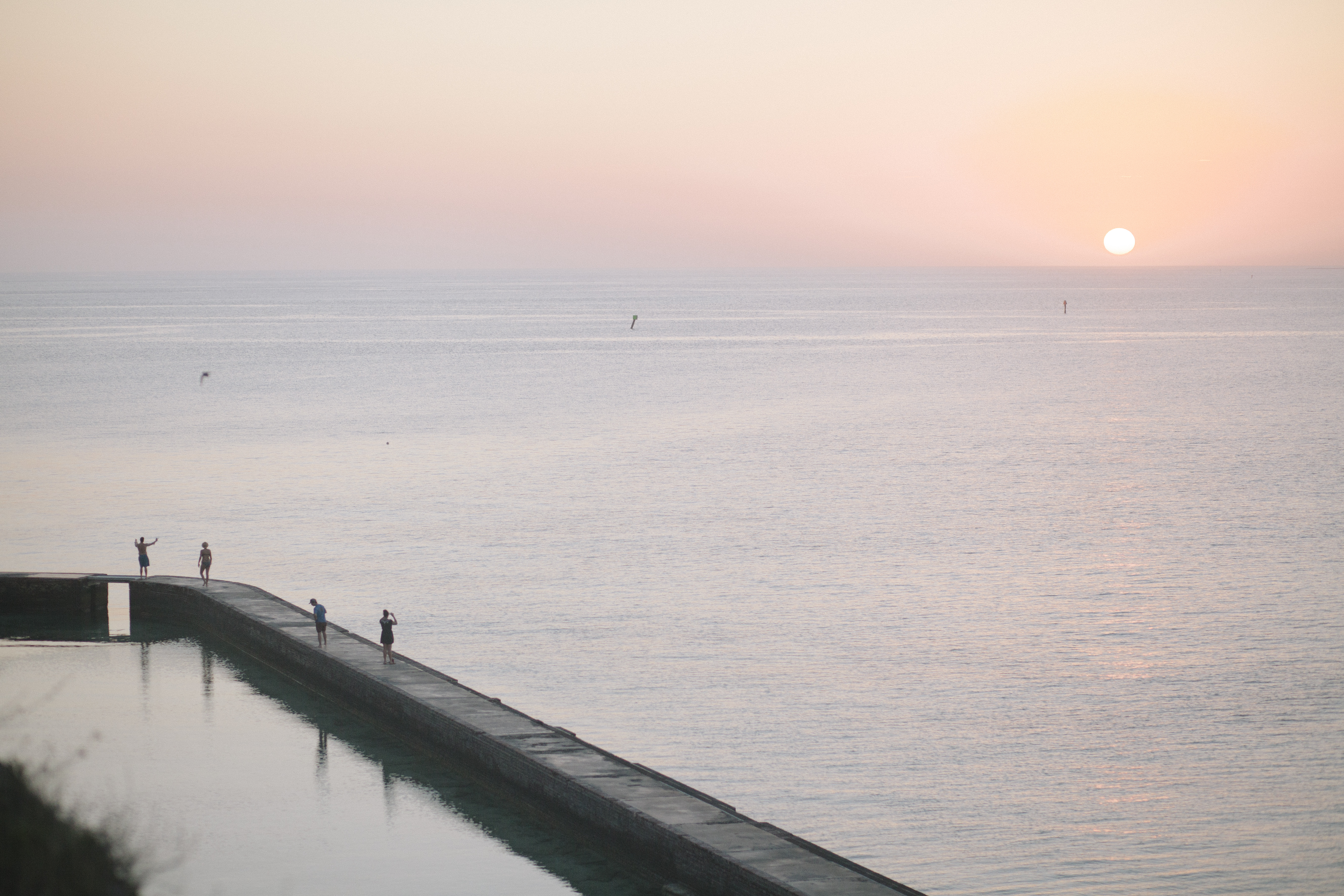 Park visitors enjoy a sunset on the moat wall.