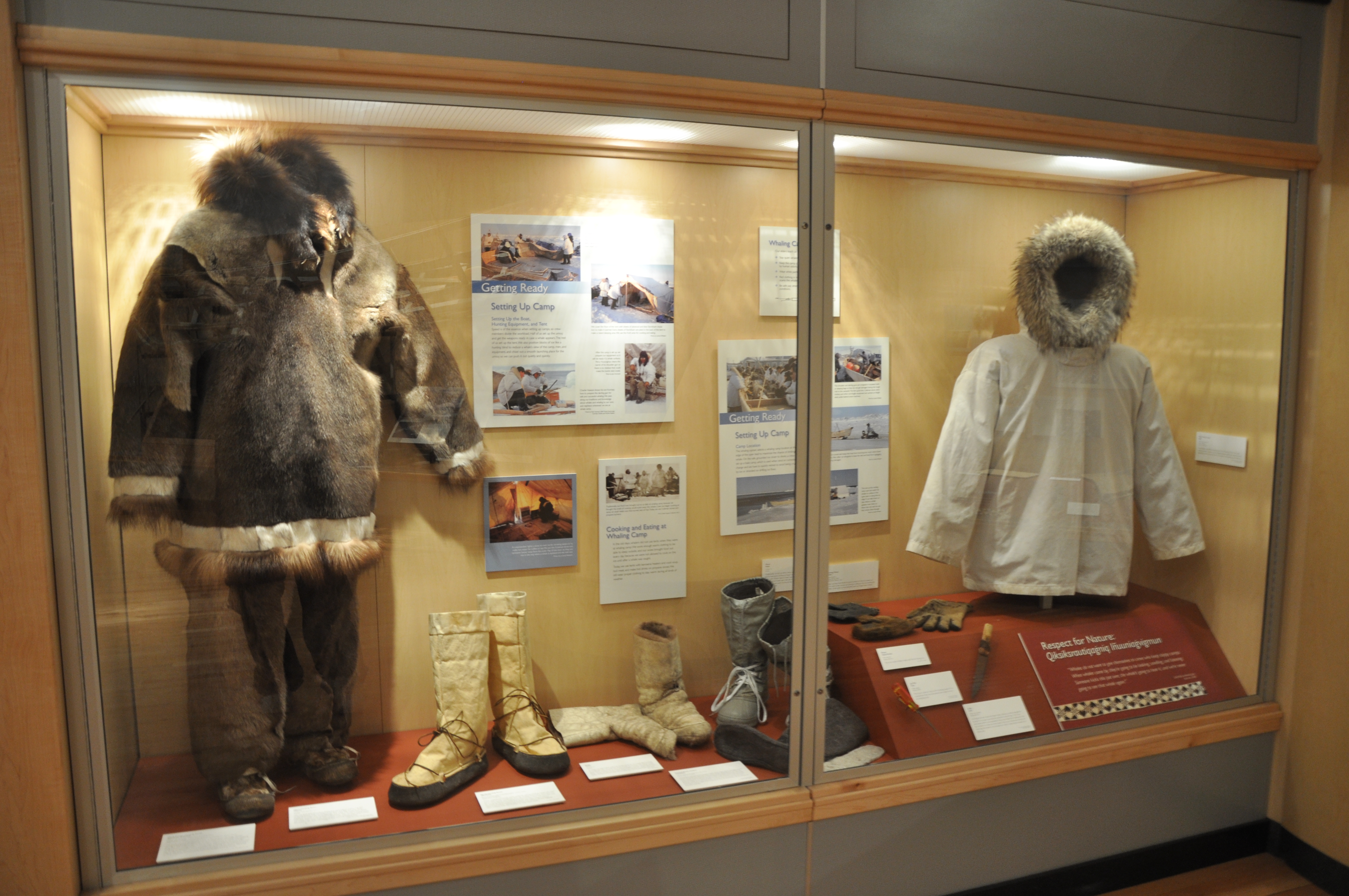 Museum exhibit case with fur parkas and boots
