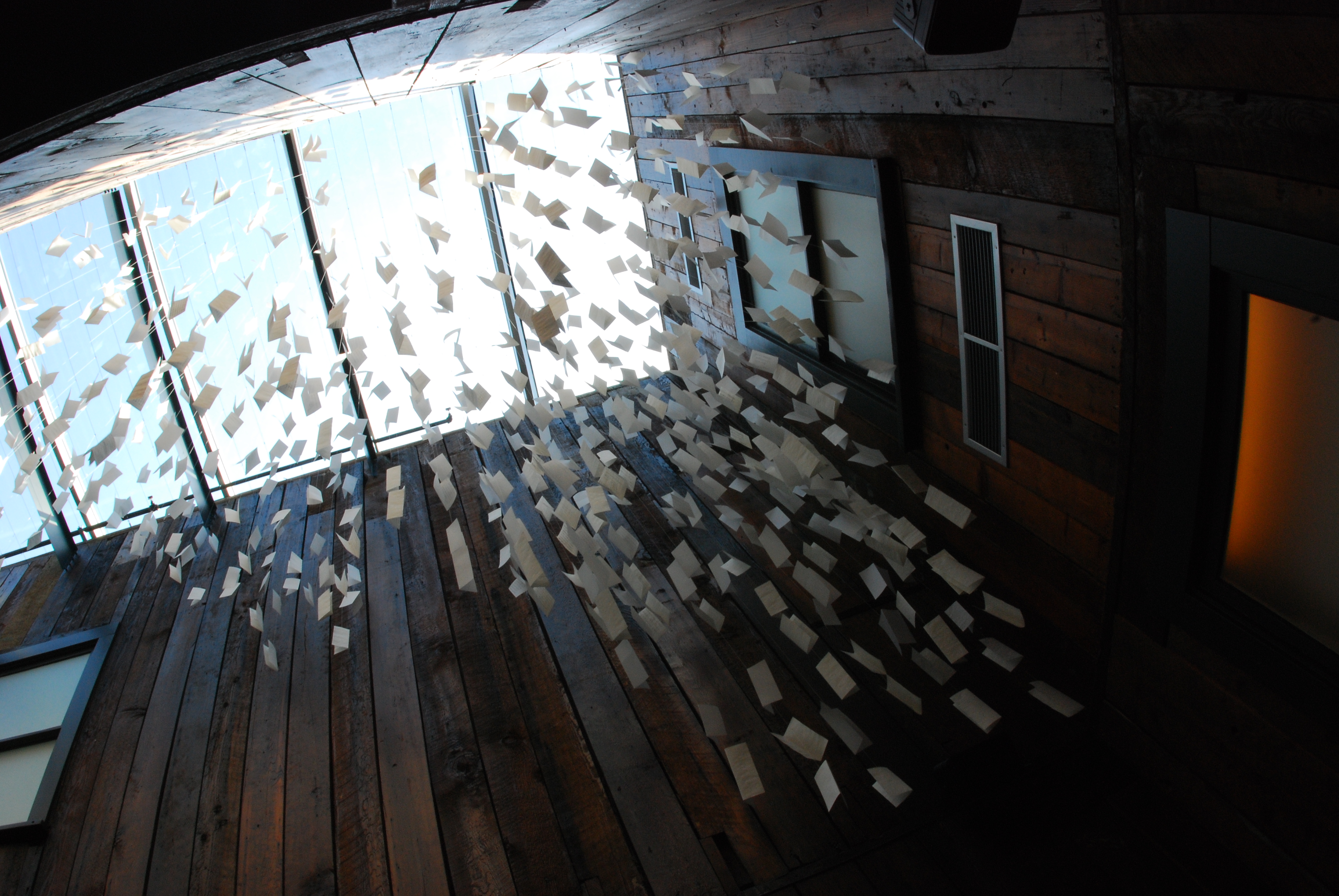 a mobile of letters written on white paper hangs in the museum lobby