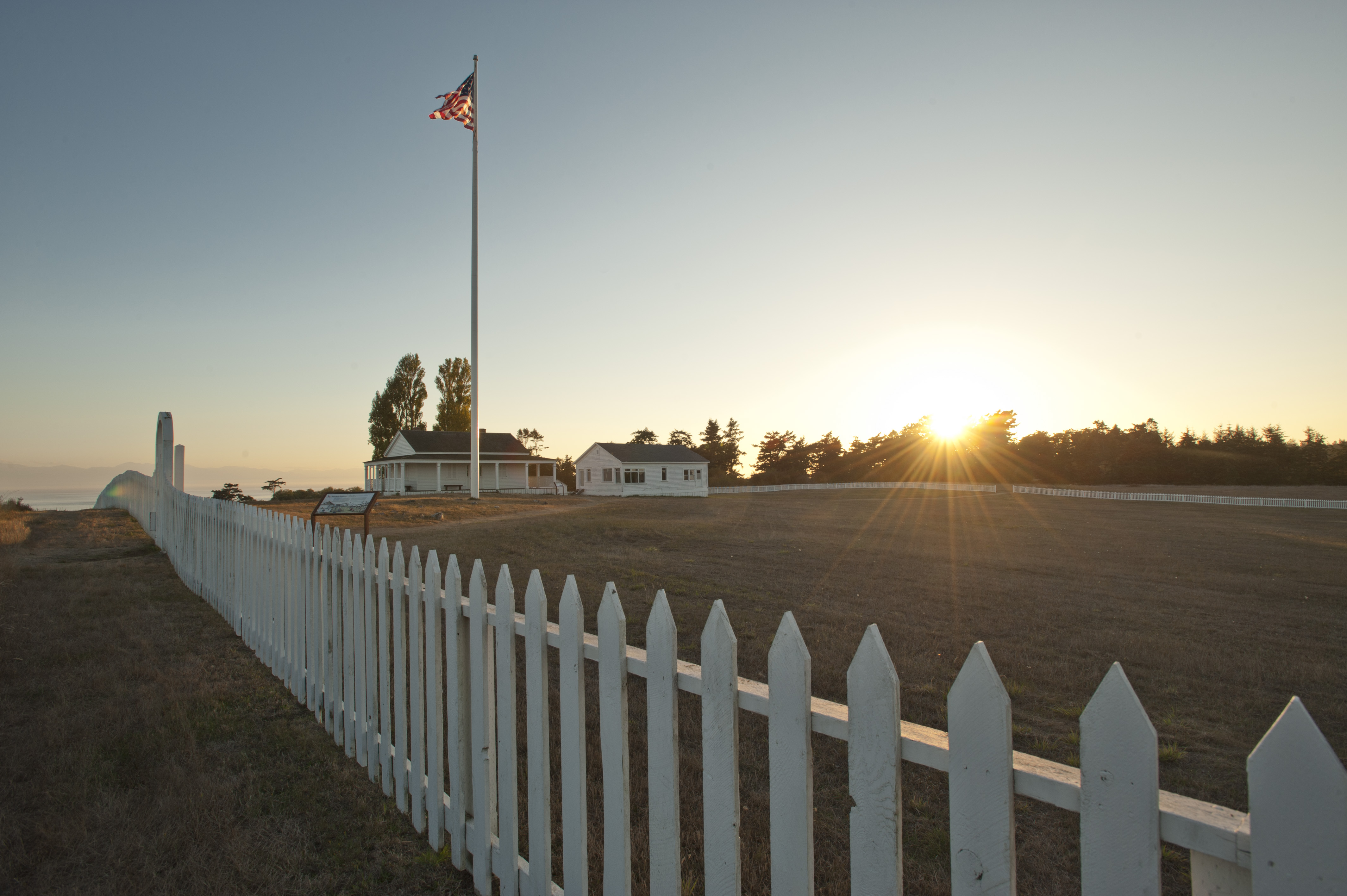 a sun setting behind historic parade grounds