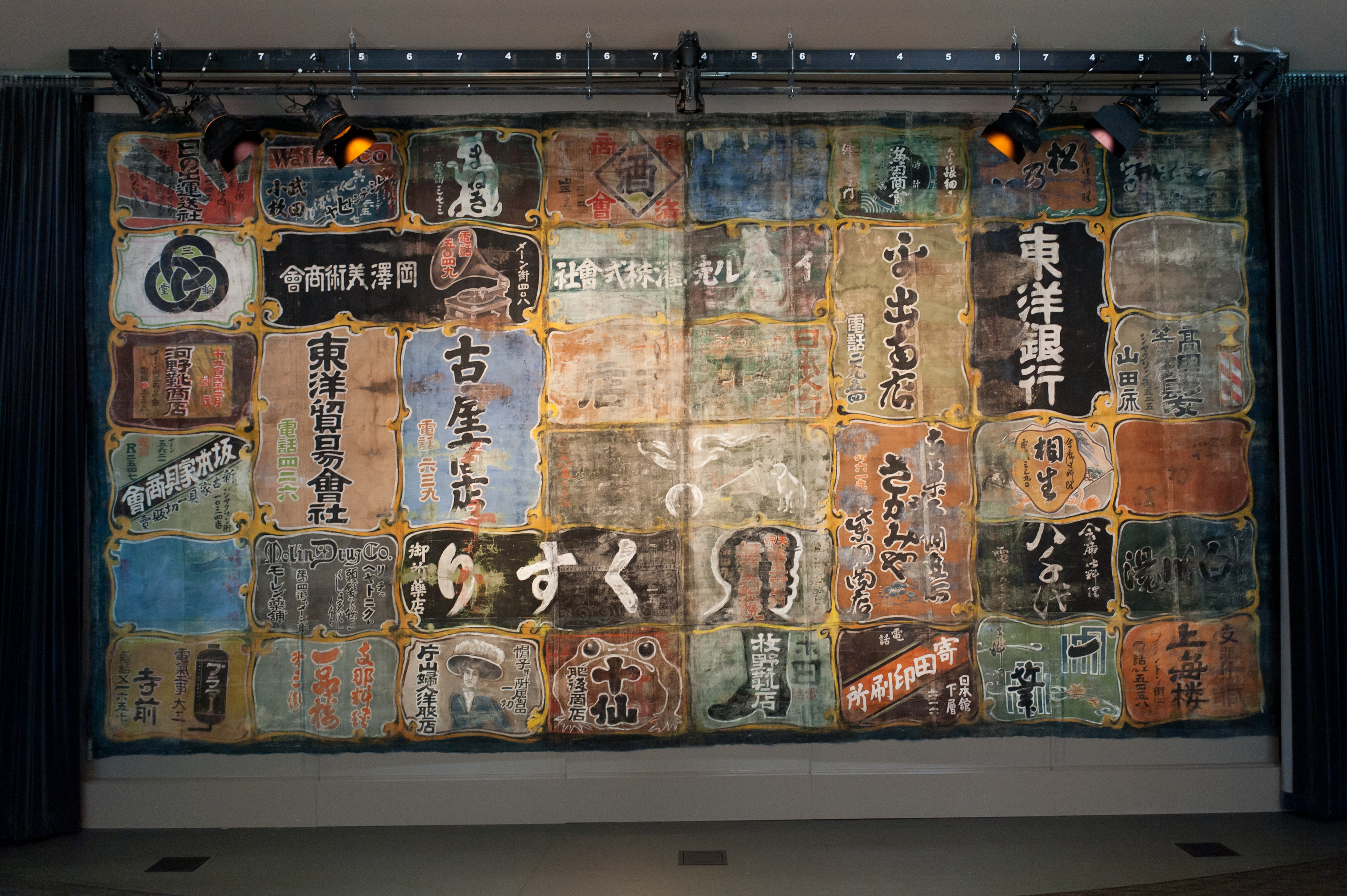 theatre curtain painted with Japanese characters advertising local businesses