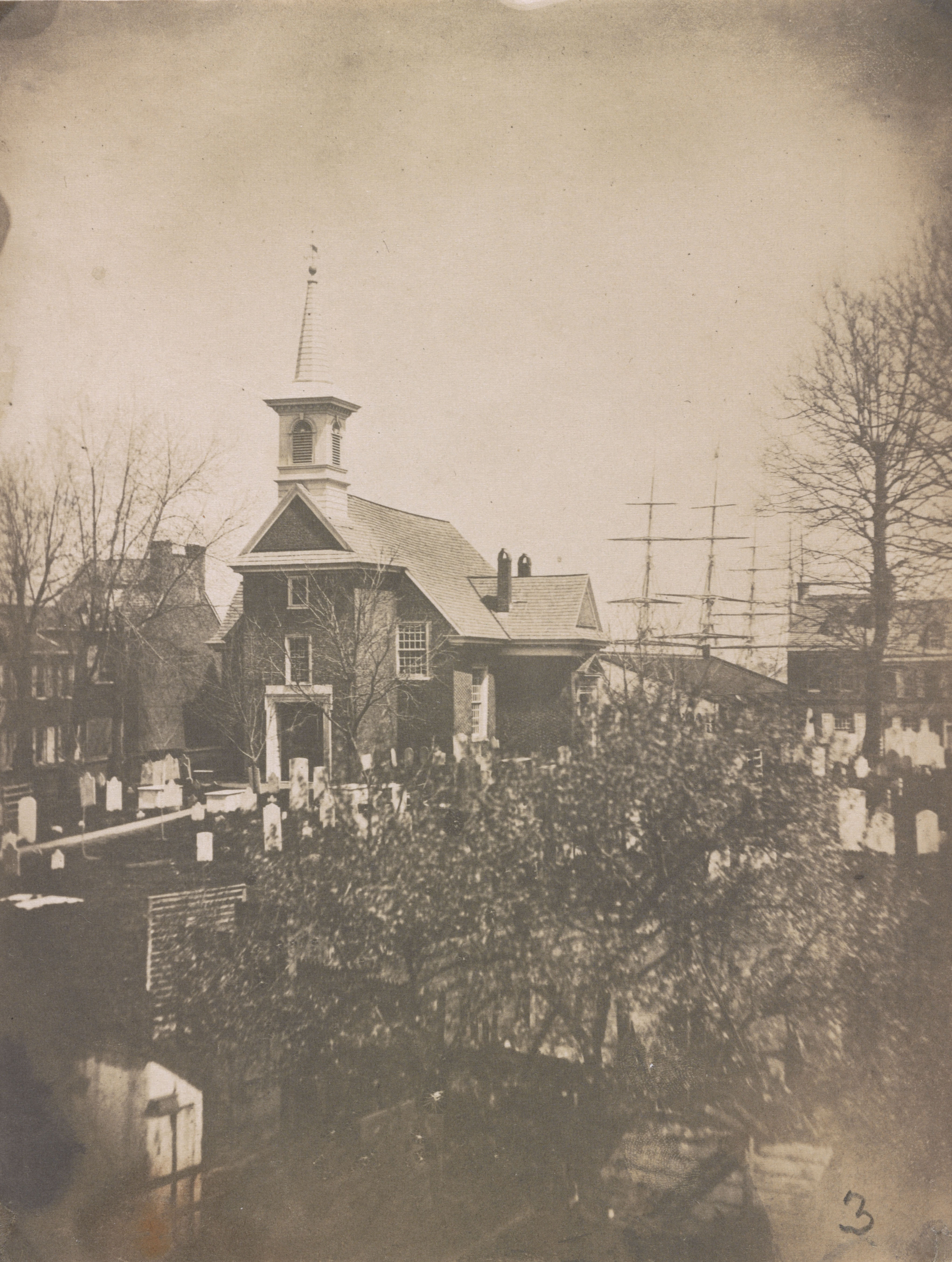 A 19th century photograph of the Gloria Dei Church, with the cemetery in the foreground.