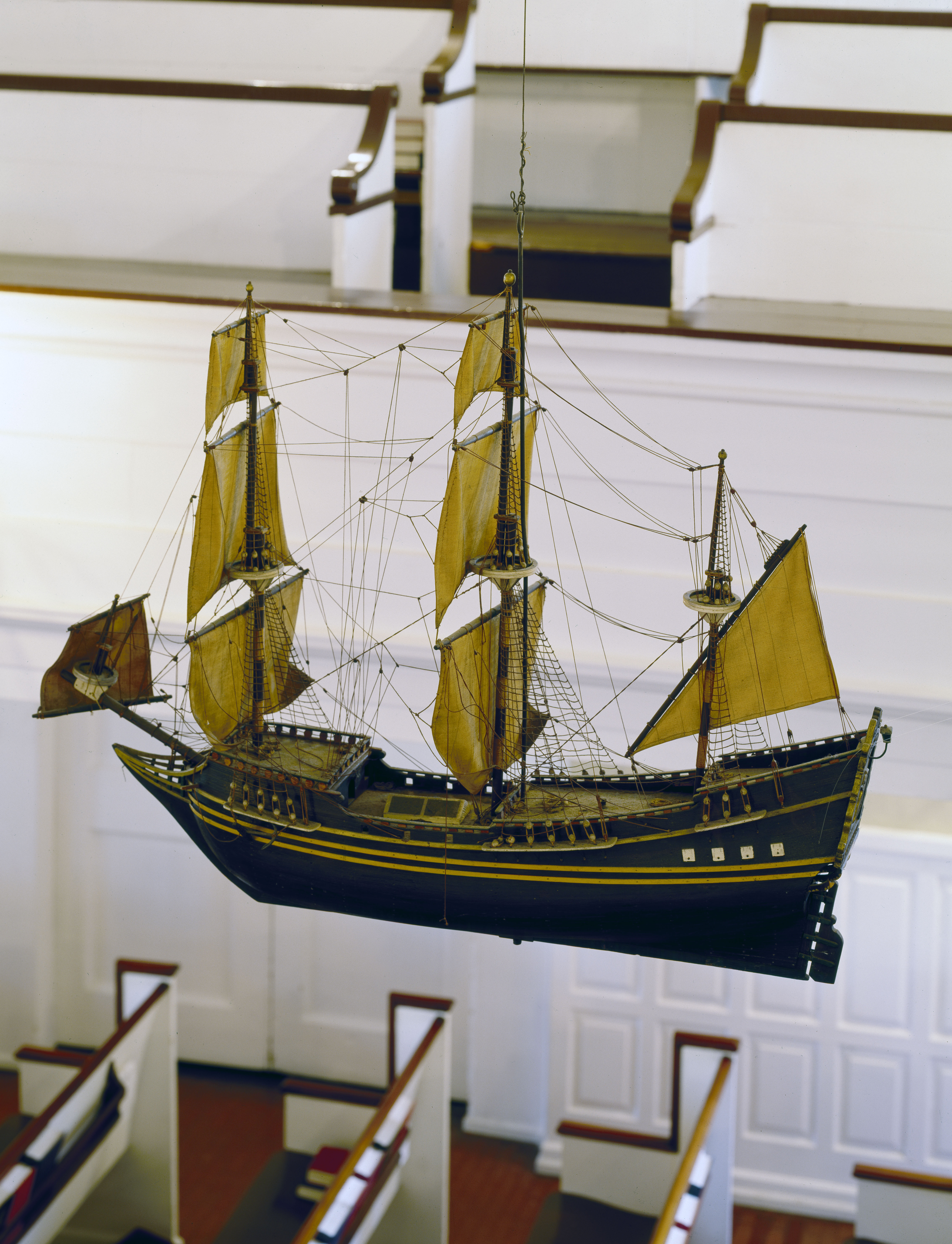 A color photo of a model tall ship hanging inside Gloria Die Church.