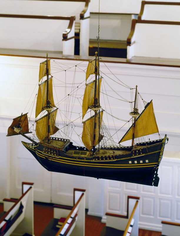 A color photo of a model tall ship hanging inside Gloria Die Church.  