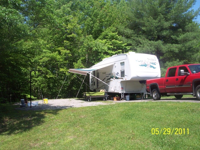 Red truck with RV camper on campsite