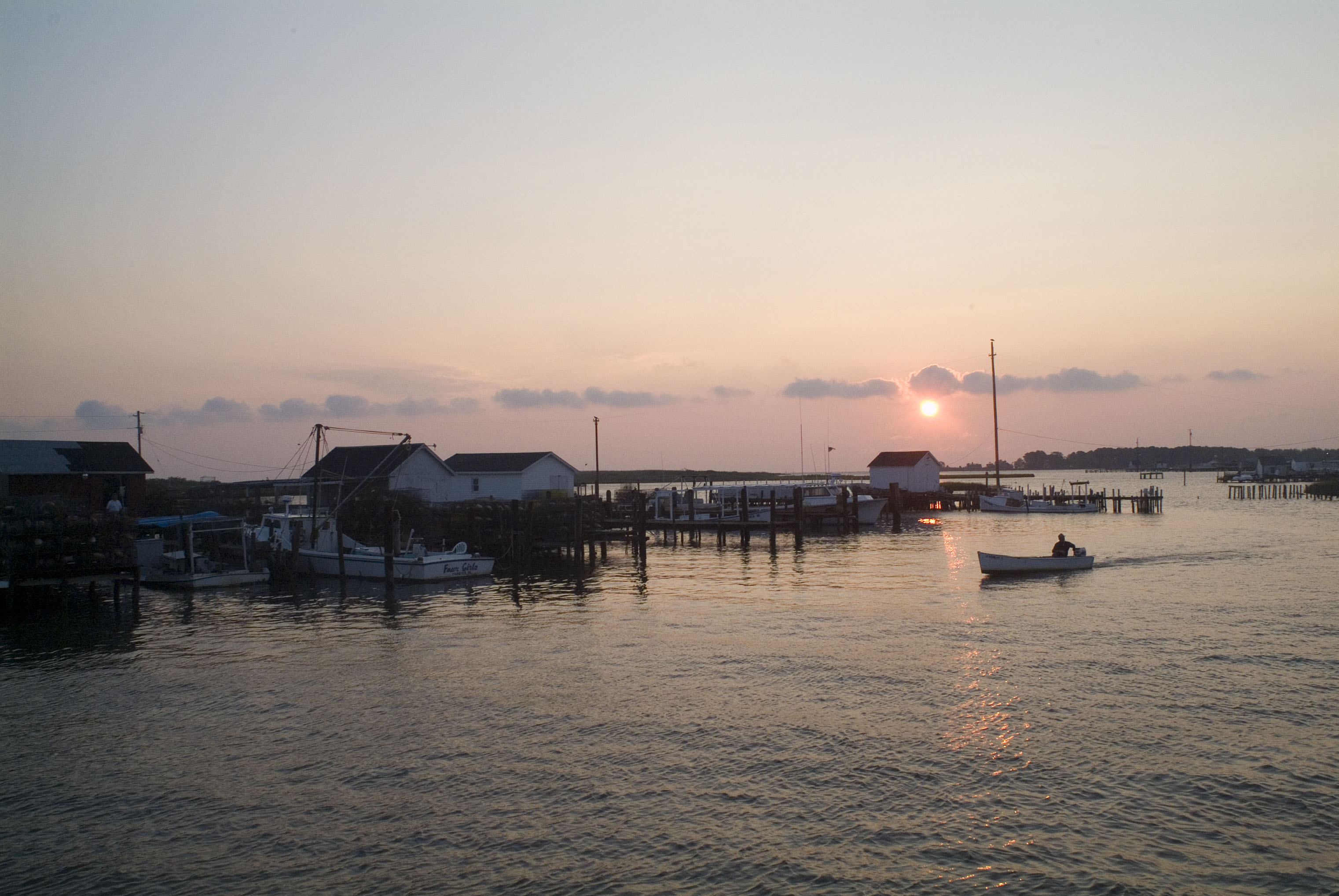 At sunset, a boater returns to the docks used by working watermen at Tangier Island.