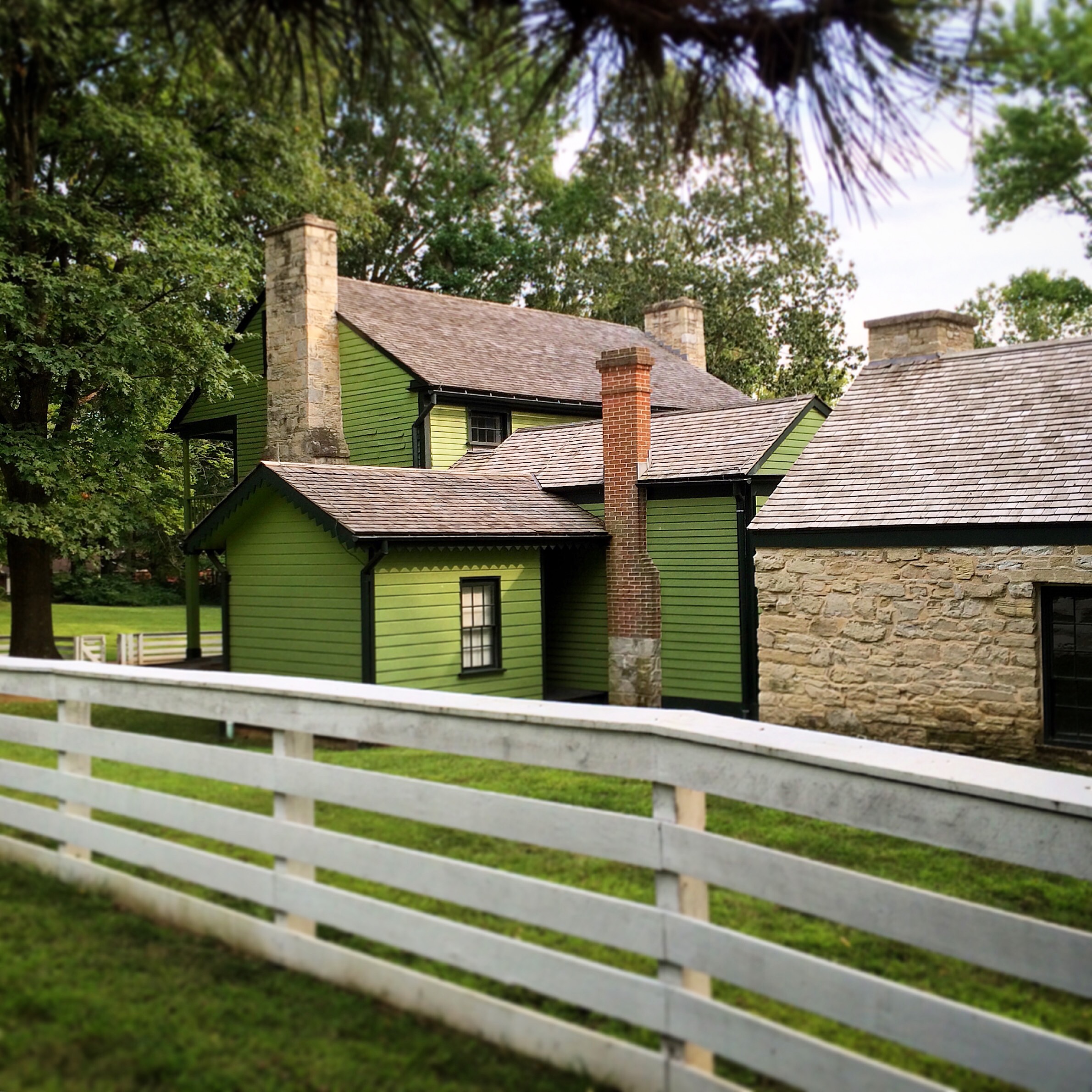 view of house from side and back. The house has several additions. Stone summer kitchen on right