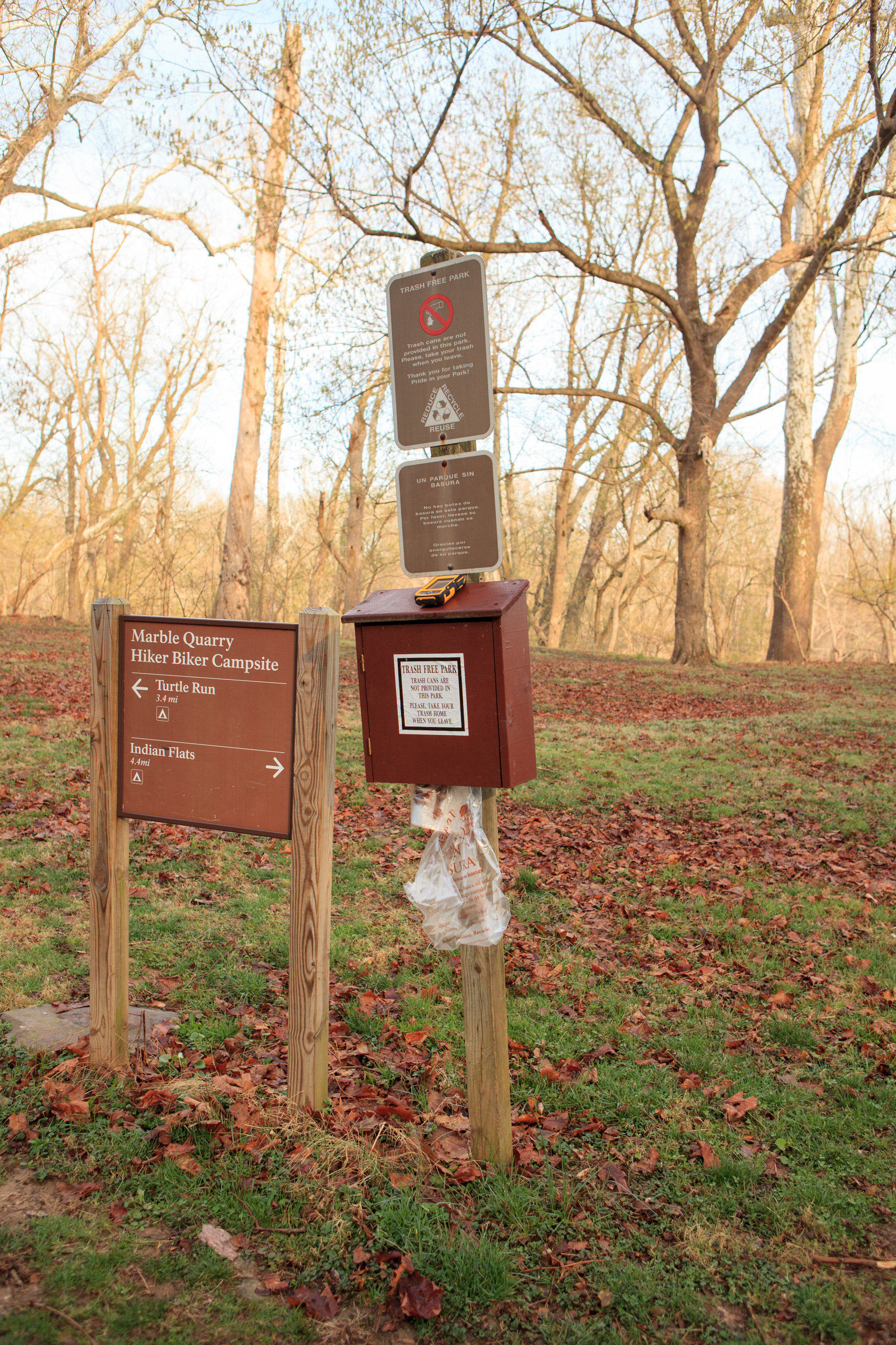 Campsite and Trash-free Park signage in front of open area.