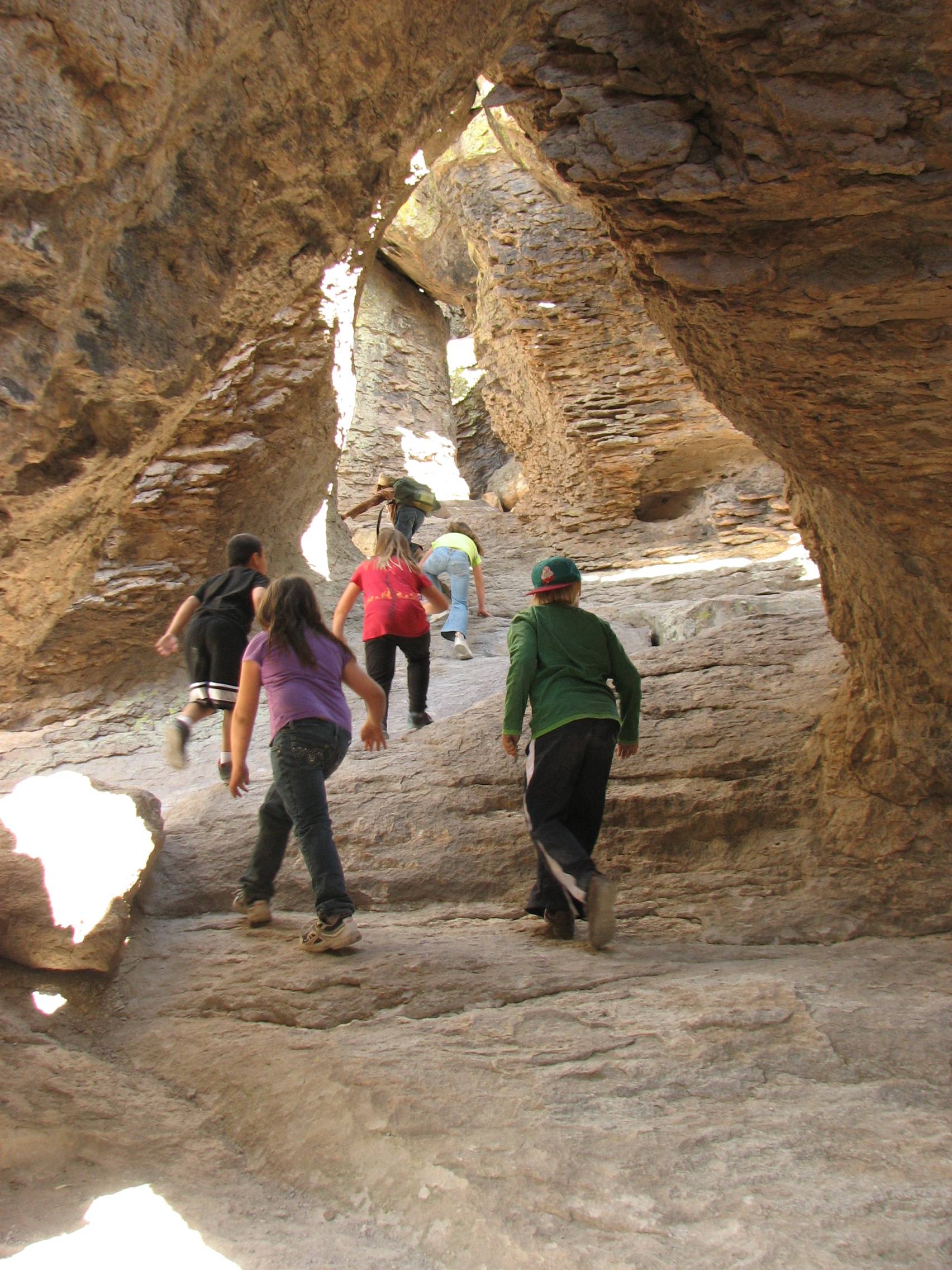 Children climb through rock archways