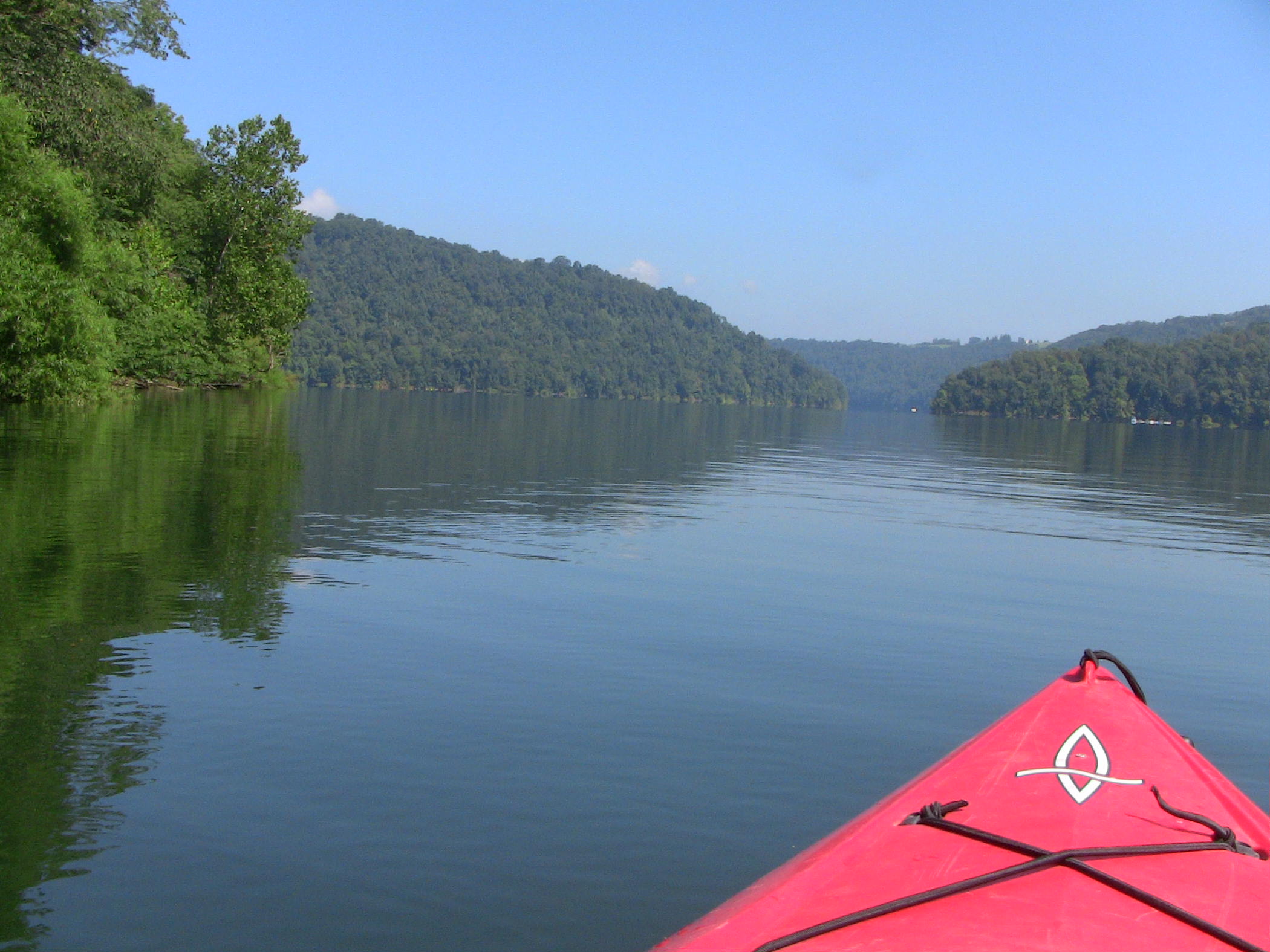 A red kayak floating on the river.