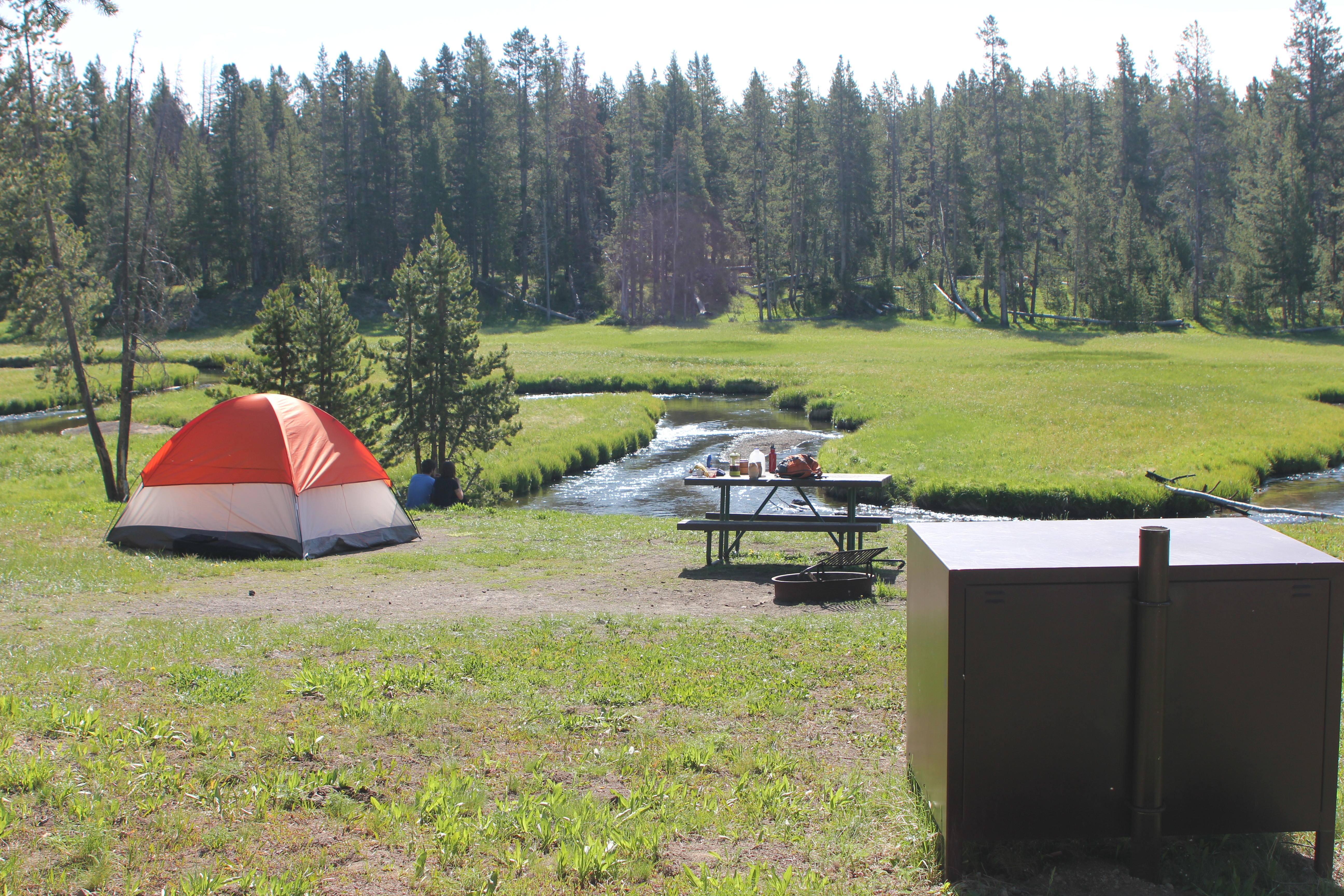 Tent campsite pitched next to nearby stream