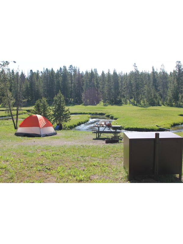 Tent campsite pitched next to nearby stream