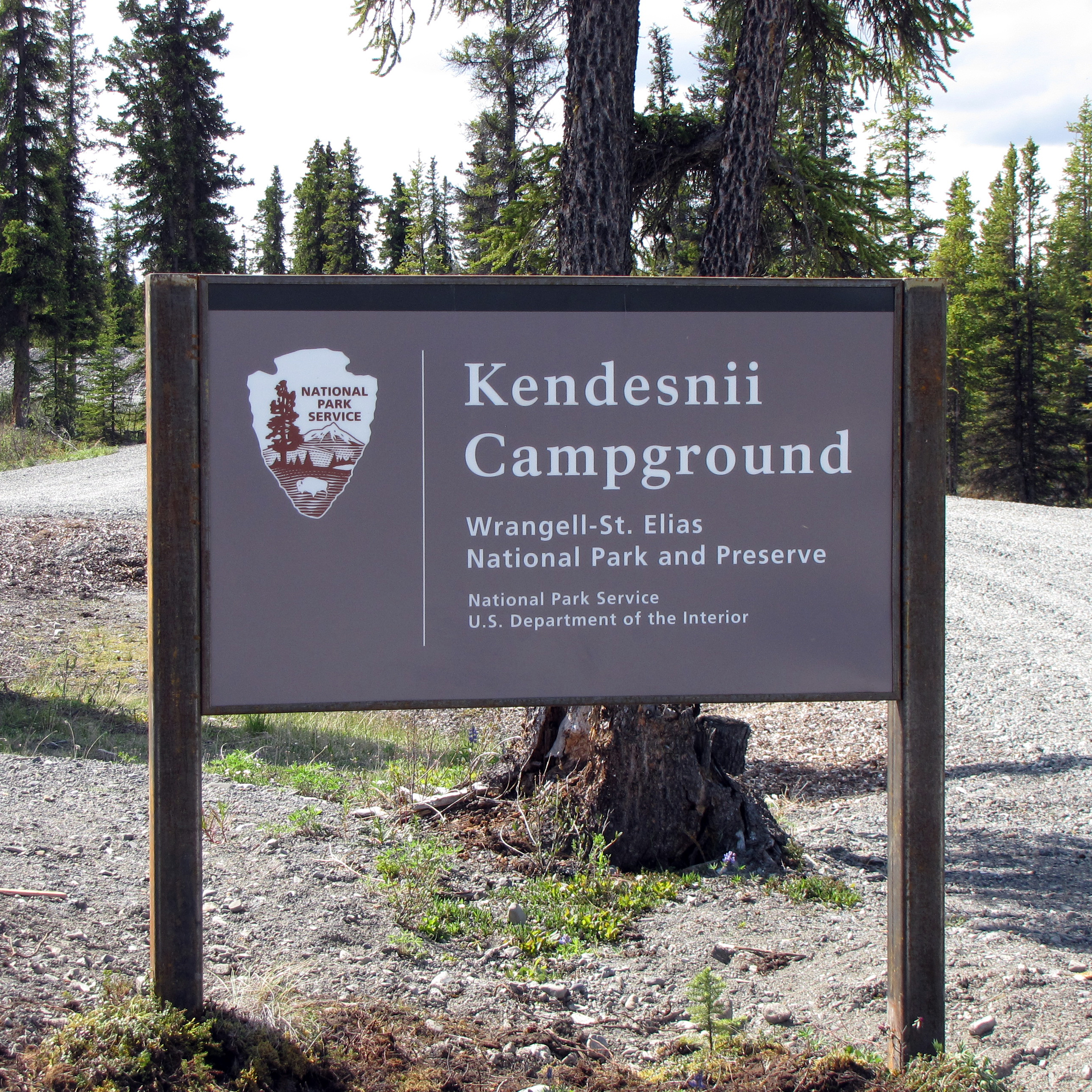 Kendesnii Campground sign with forest in the background.