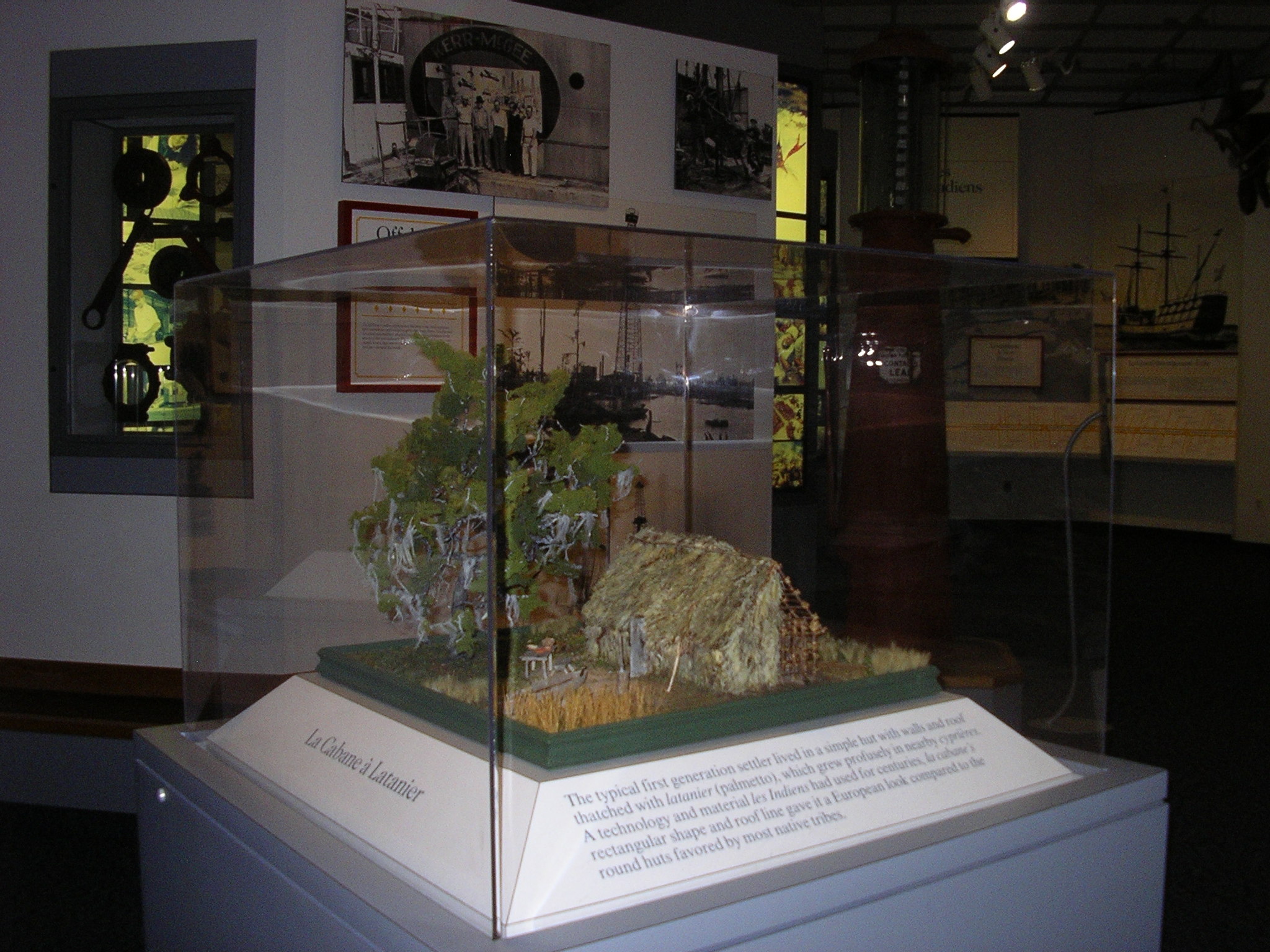Model of an early Acadian home sits in a glass case
