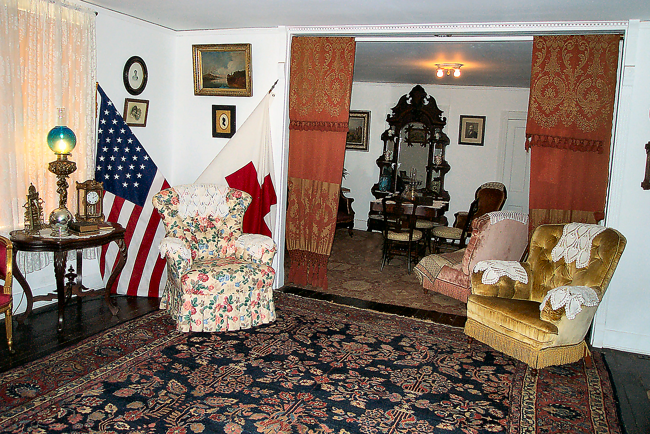 front parlor, two easy chairs, American Flag and Red Cross flag in corner behind one chair.
