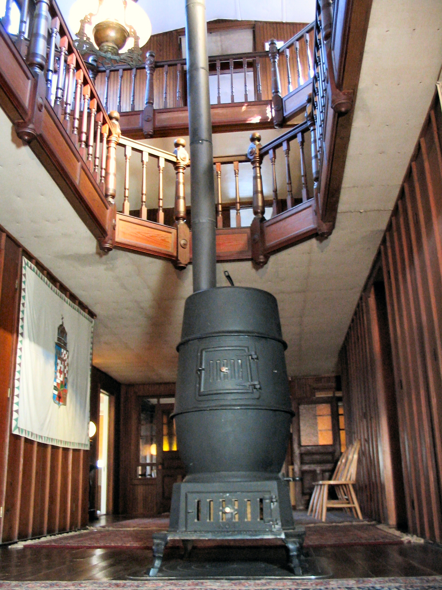 large potbelly stove in center hallway with open view to third floor