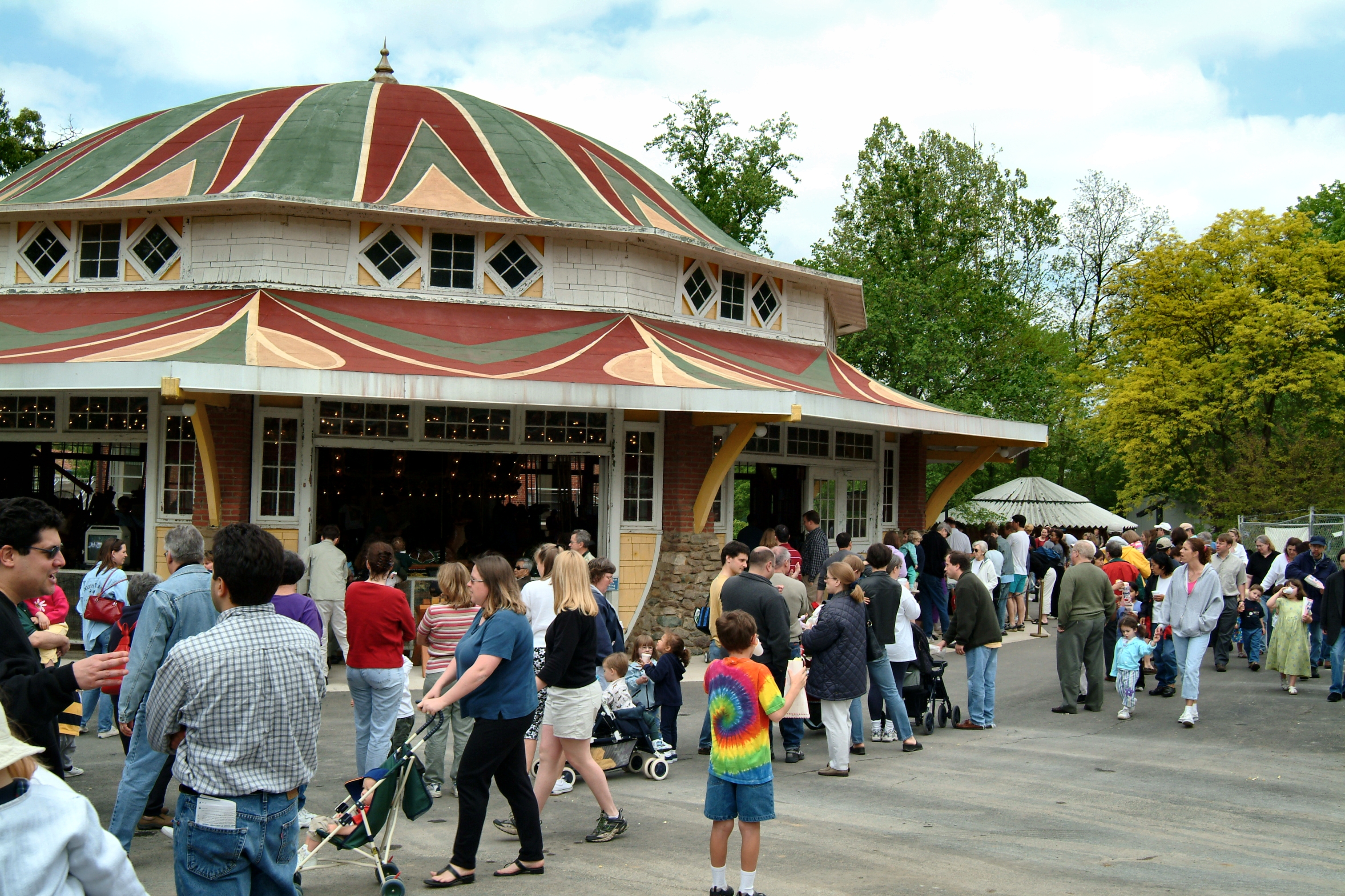 groups of families, adults and children strolling in Glen Echo Park near Carousel Building