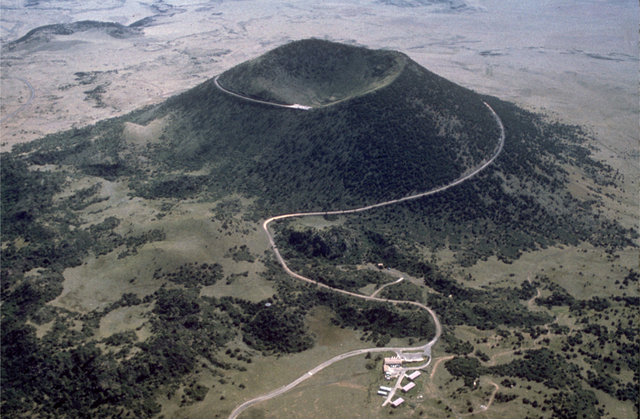 View of cinder cone volcano and the road leading to the top of the volcano as seen from the air.