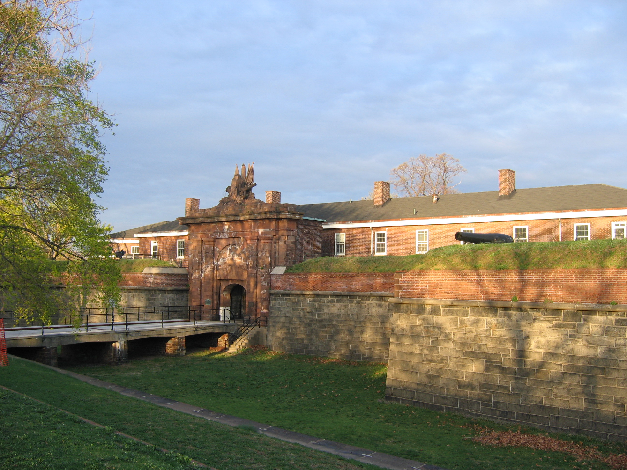 Bridge over dry moat leading into a gated fort.