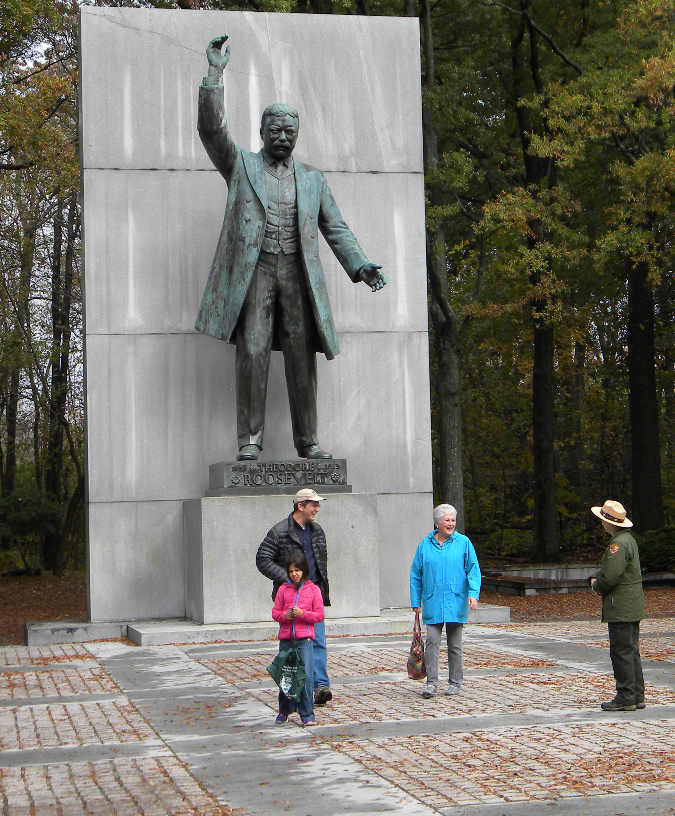 Three people with Park Ranger at Theodore Roosevelt Memorial.