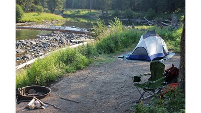 Tent and camp chair at campsite