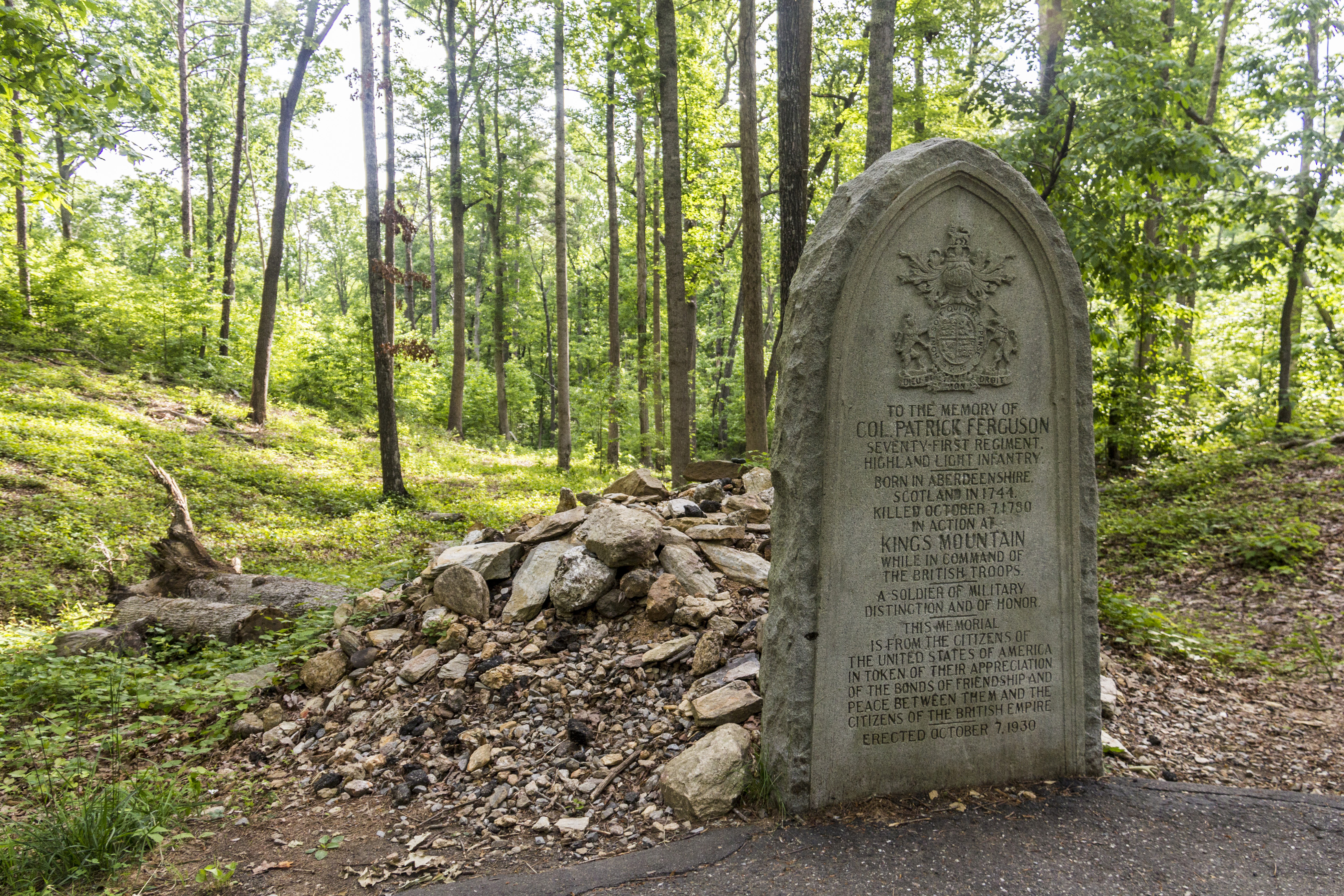 An oval gravestone for Maj Patrick Ferguson is in front of his stone covered grave.