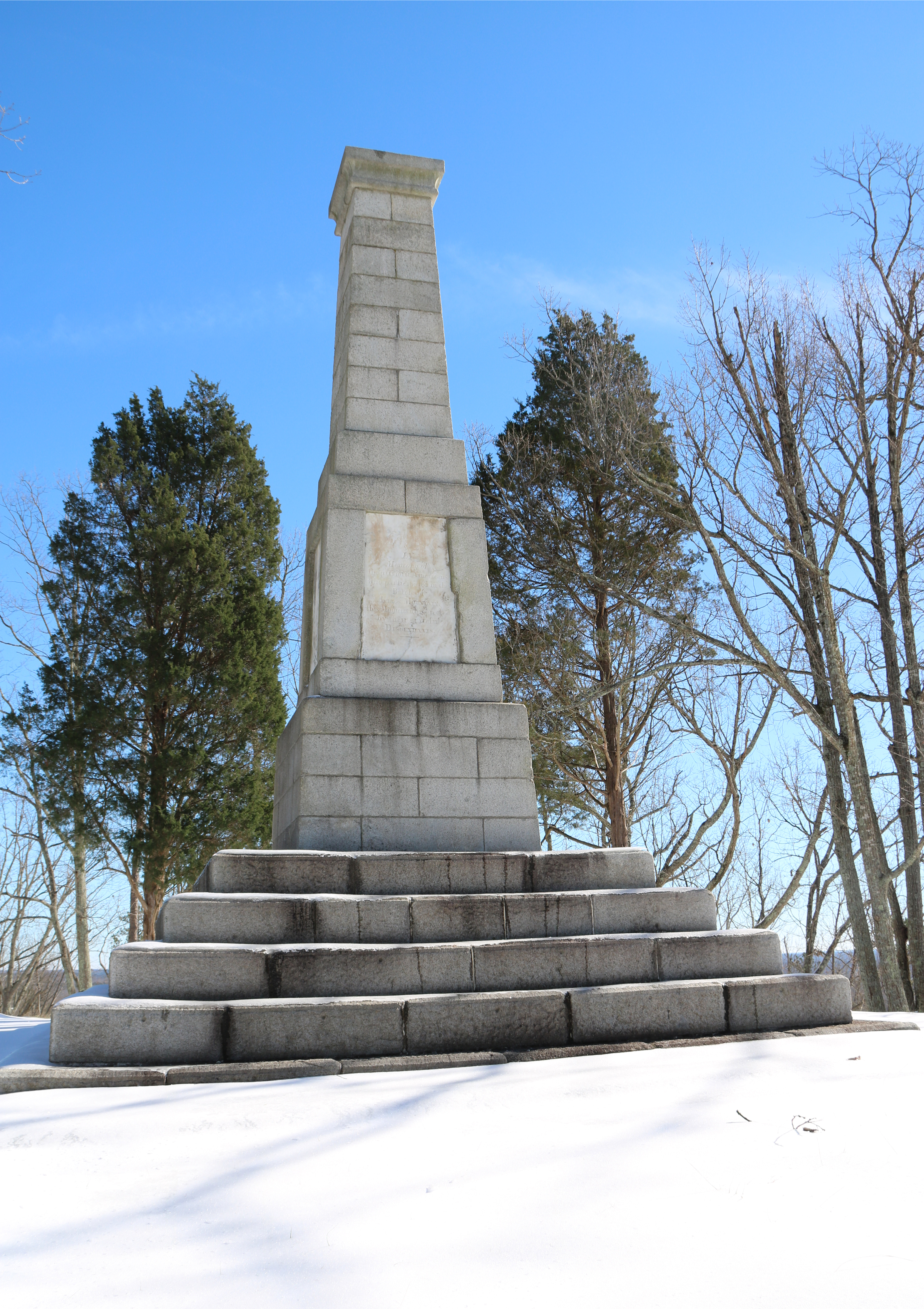 Snow covers the ground in front of the Centennial Monument.