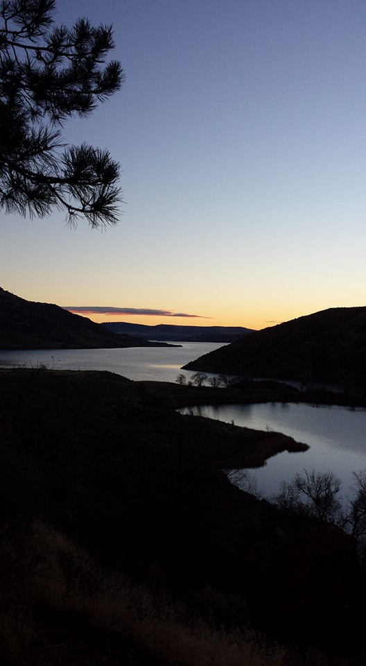 A glow is coming over the horizon and bringing first light to Lake Roosevelt and Crescent Bay Lake.