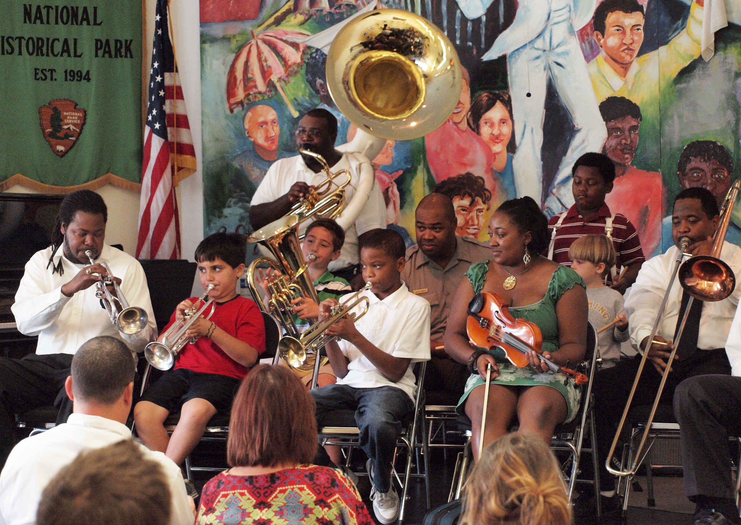 Kids and adults playing instruments on a stage