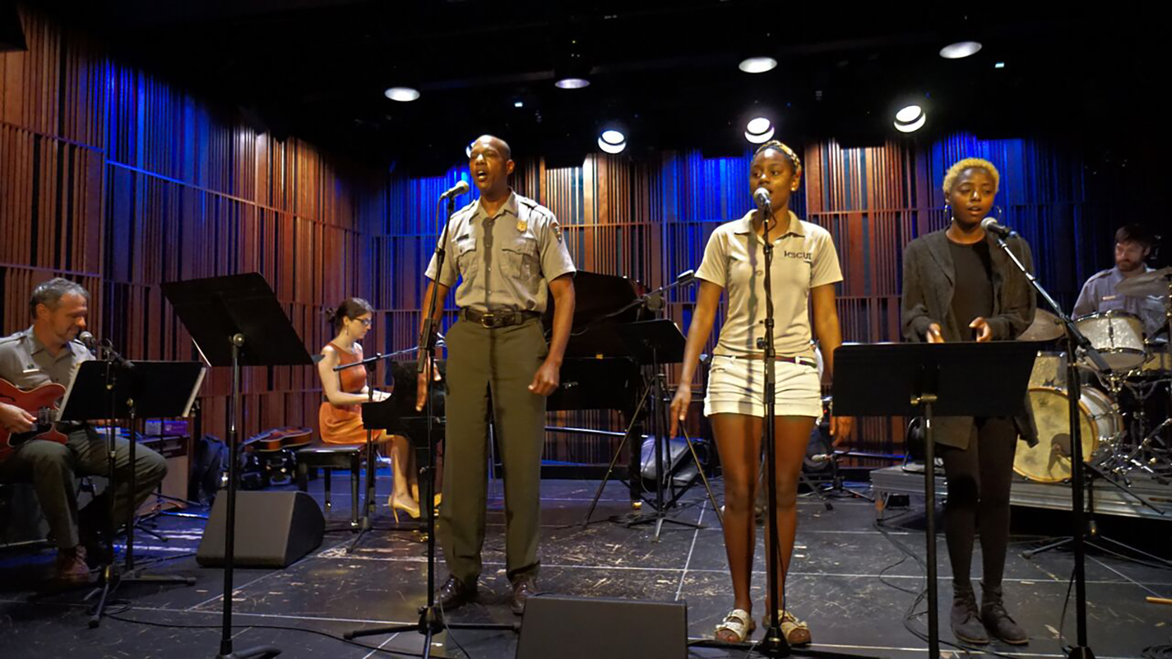 Rangers and others sing and play on a stage