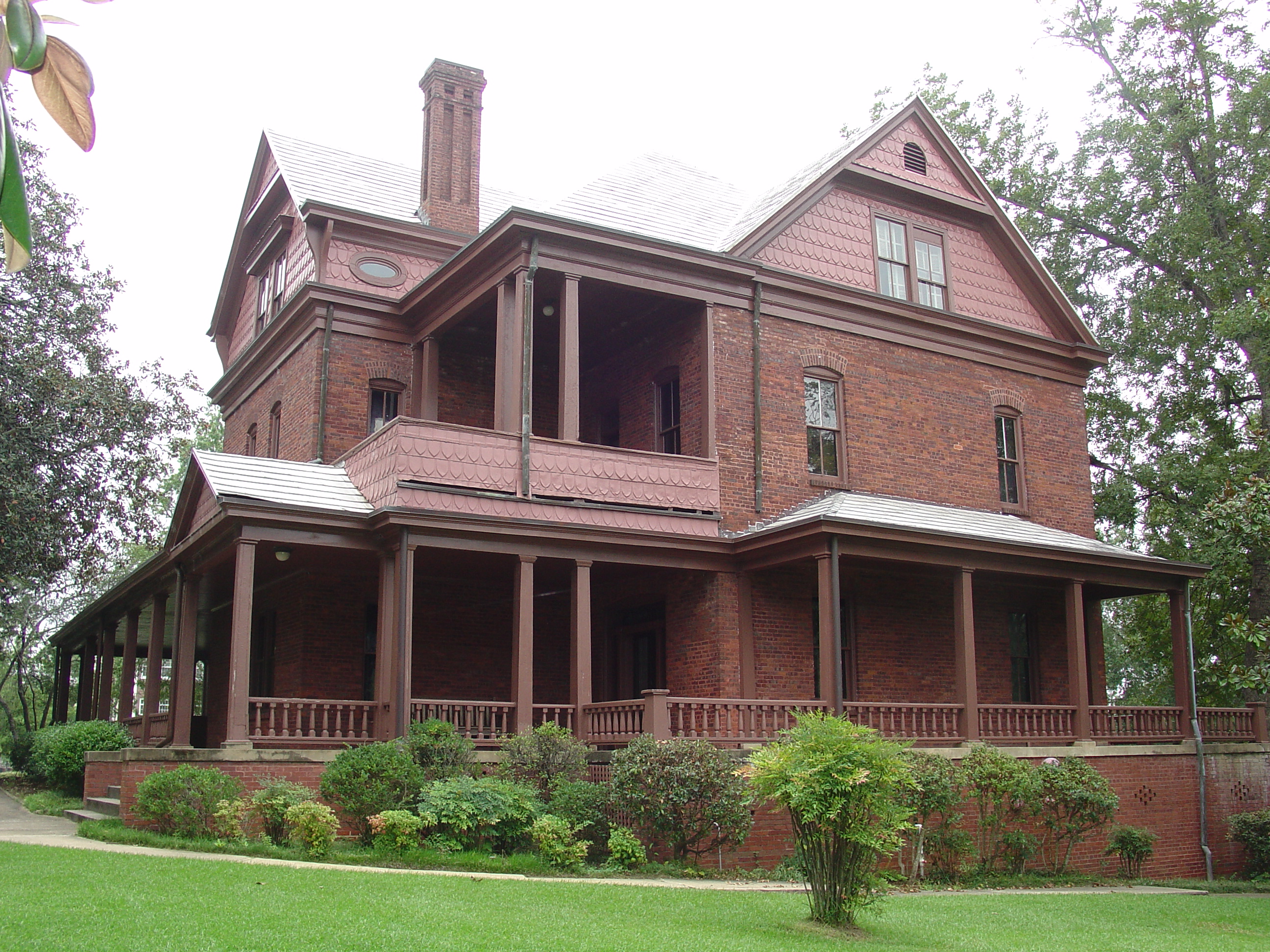 A three story Queen Anne Revival style red brick house