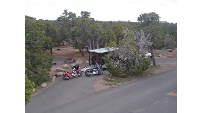 Two motorcycles behind a trailer in a campsite