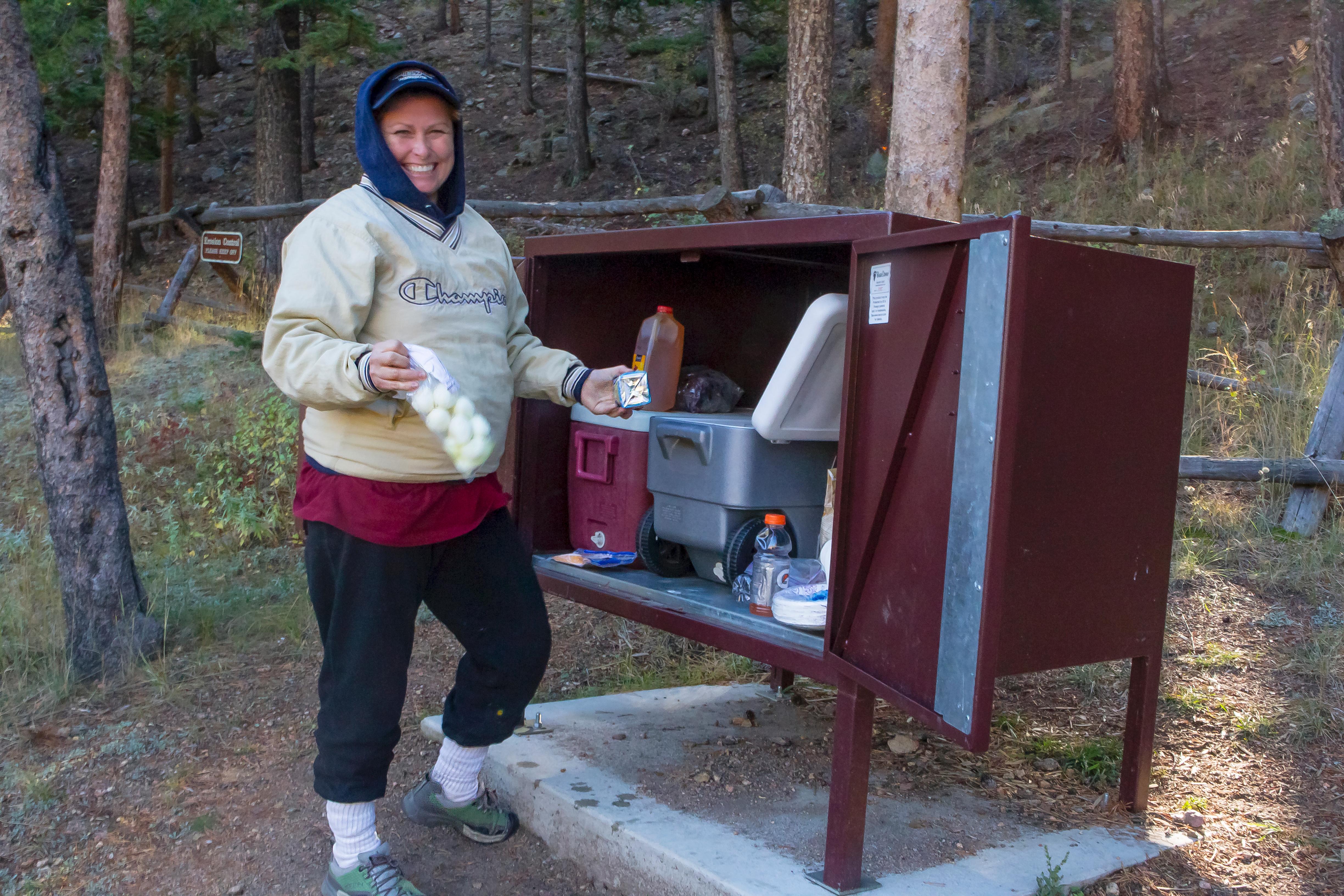 A visitor places food in a food storage locker