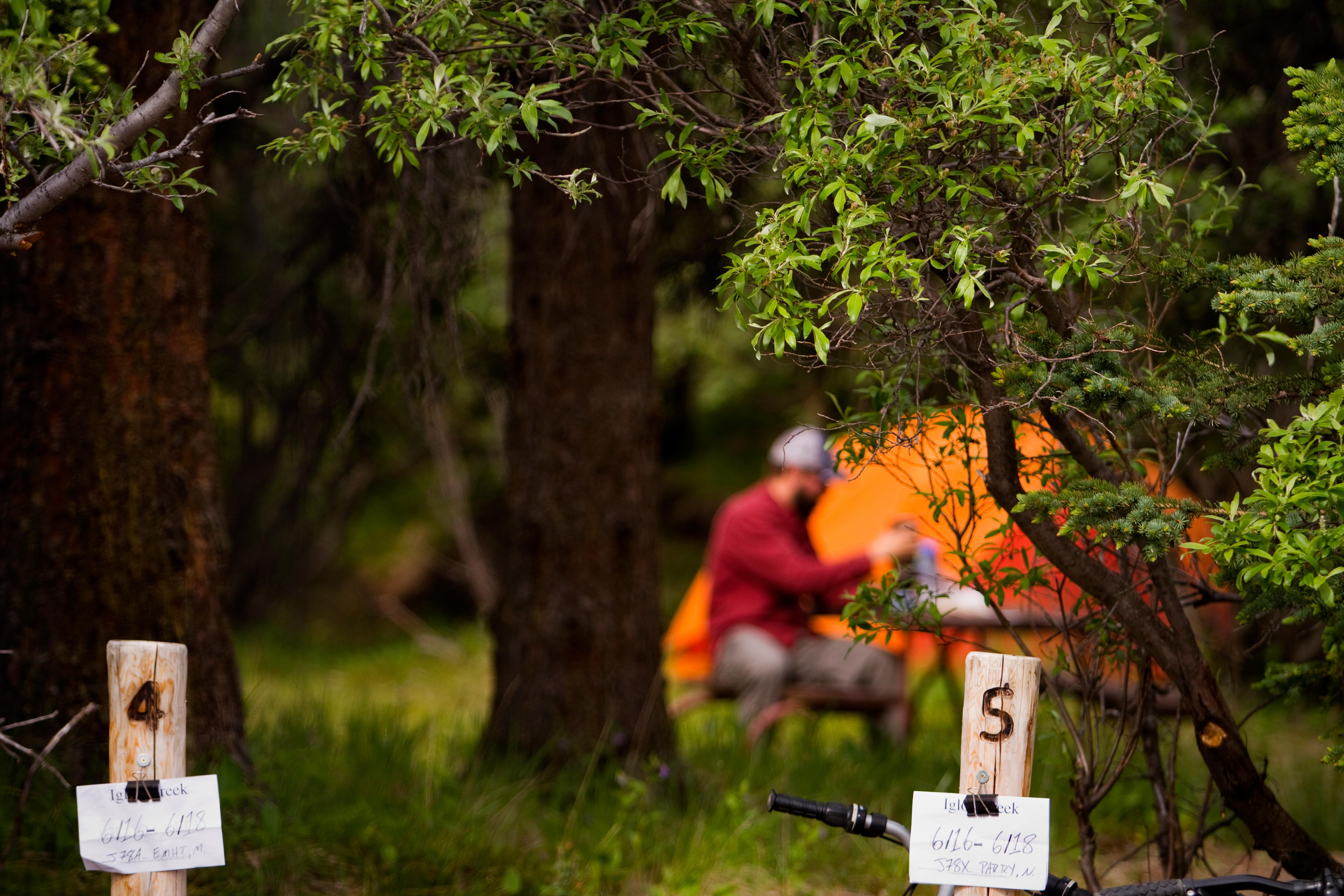 person sitting near an orange tent