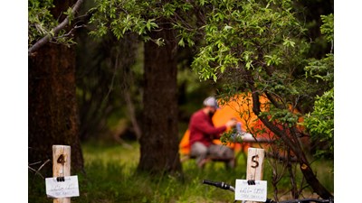 person sitting near an orange tent