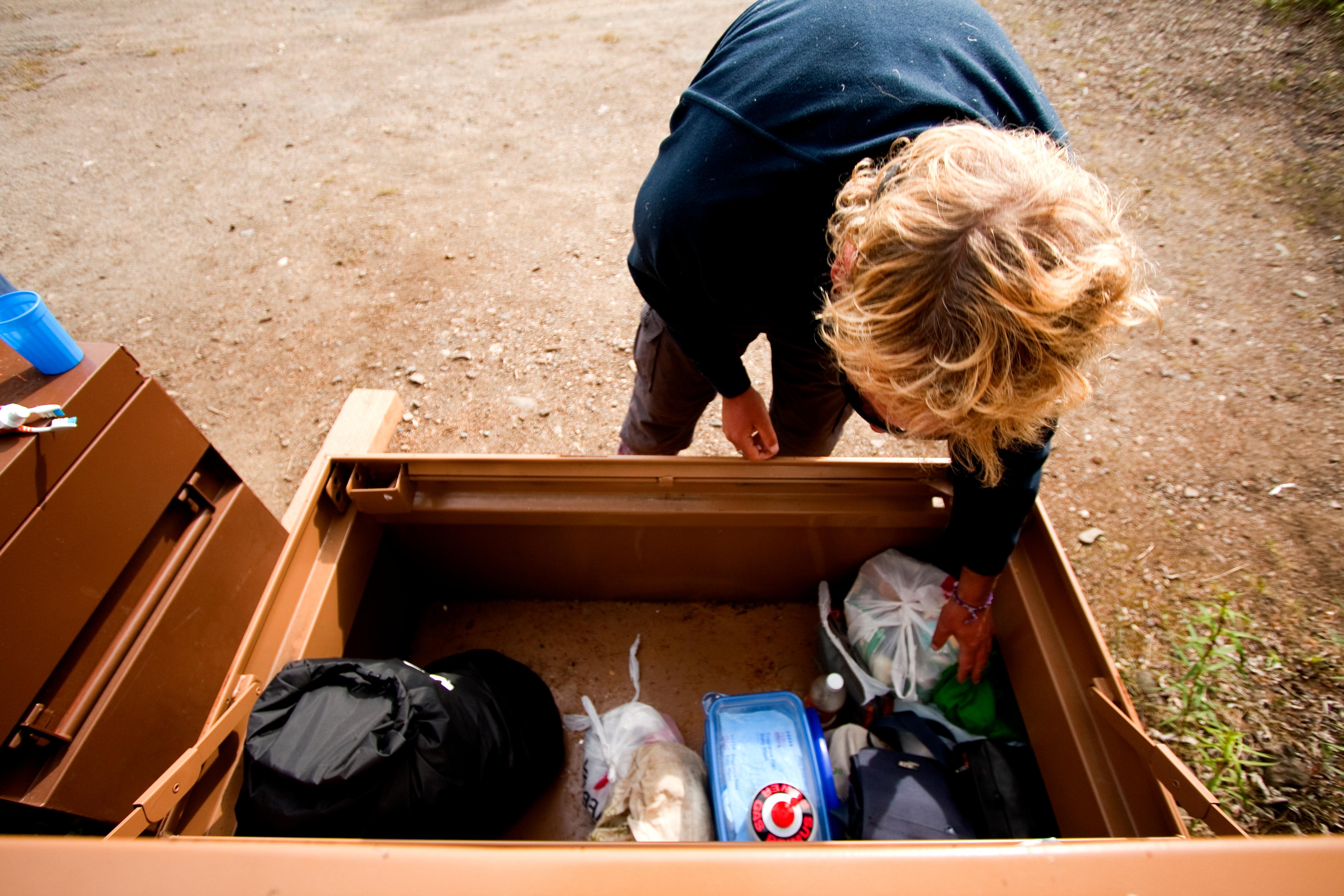 a woman placing food into a large metal locker
